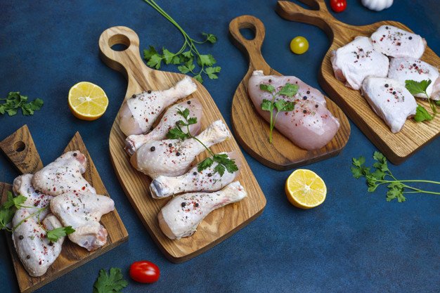 Pollo crudo rodeado de vegetales. │Foto: Freepik