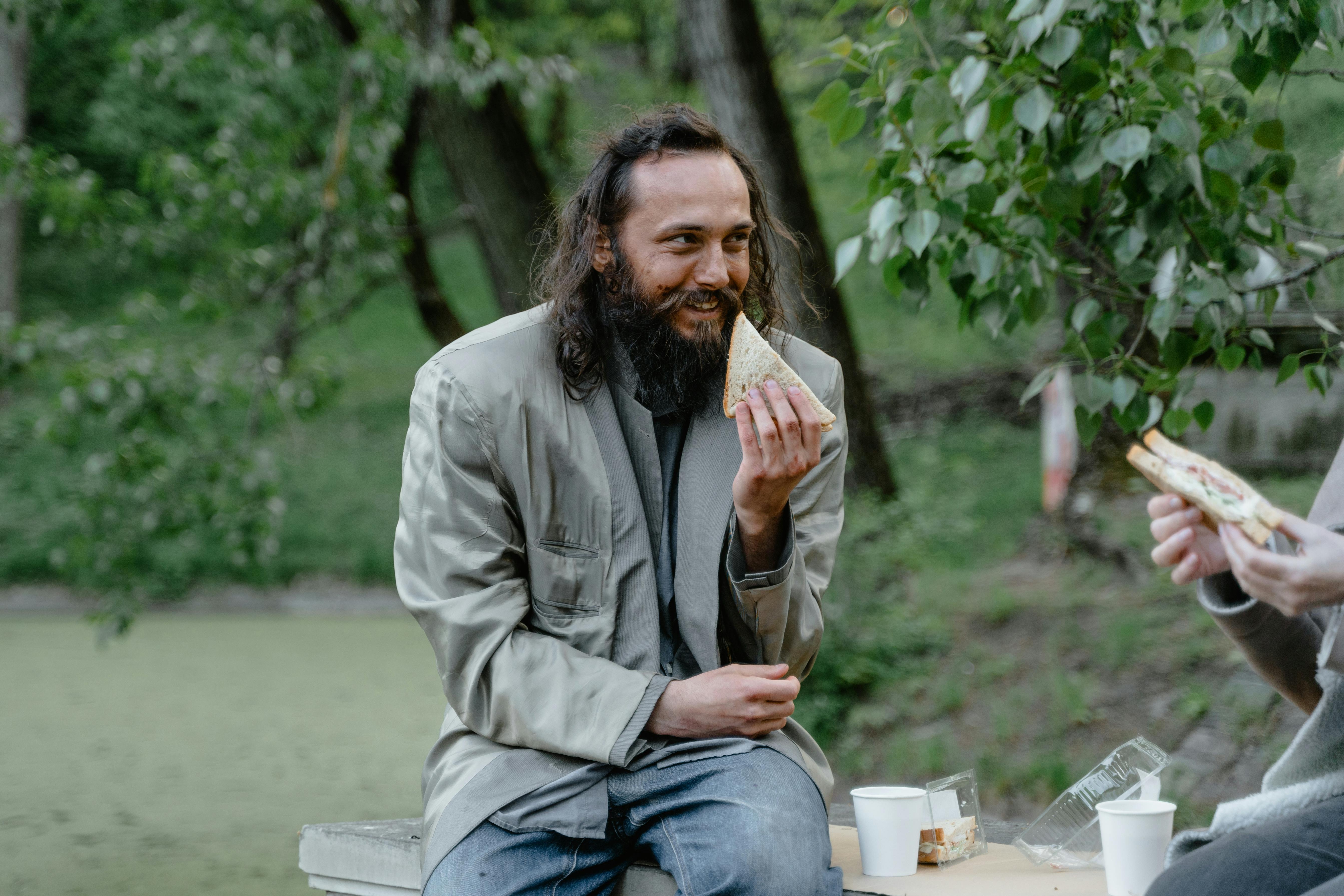 A man eating food on a park bench | Source: Pexels