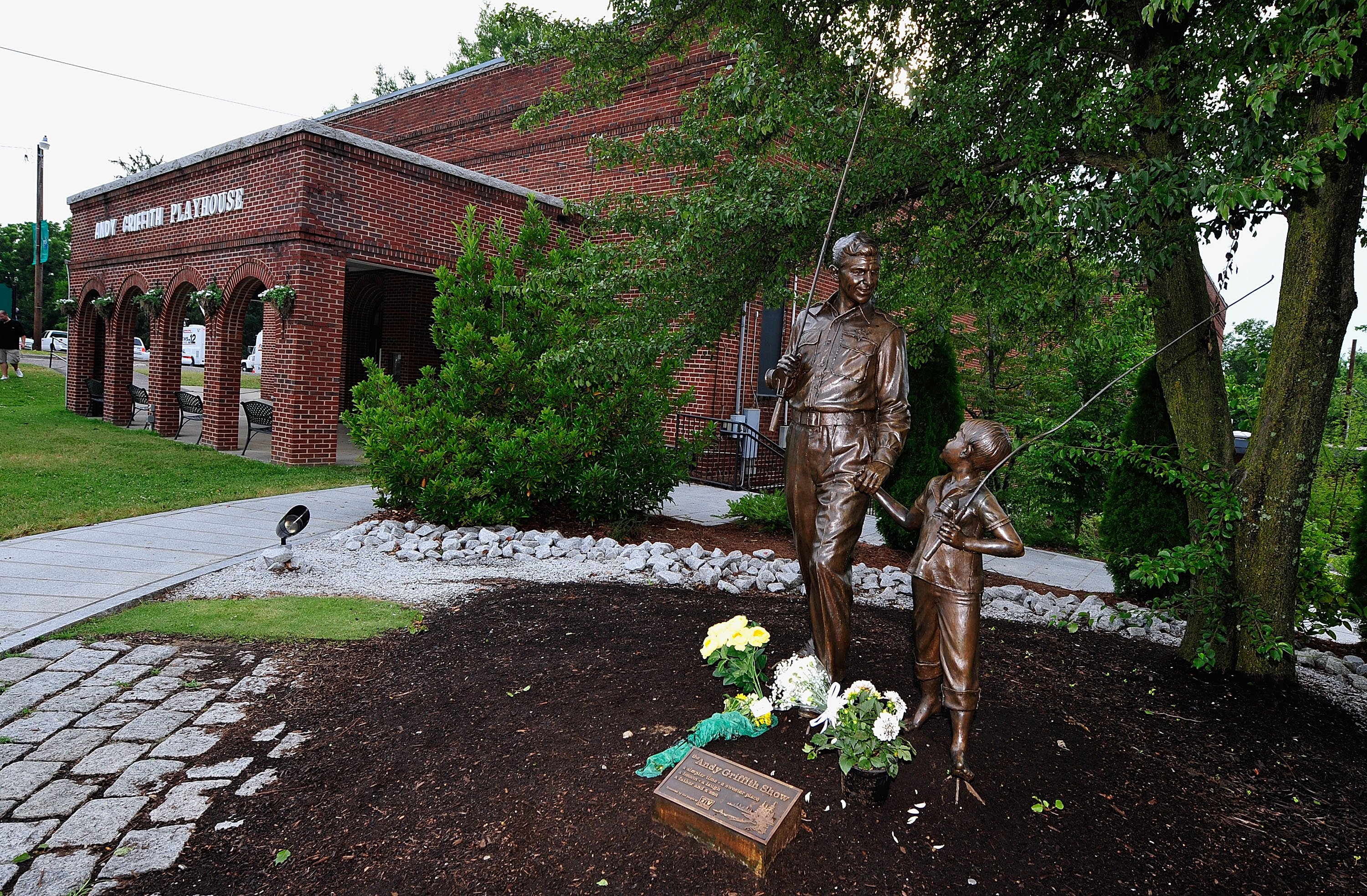 Visitors leave flowers next to a statue outside of the Andy Griffith Museum on July 3, 2012, in Mt Airy, North Carolina. | Source: Getty Images