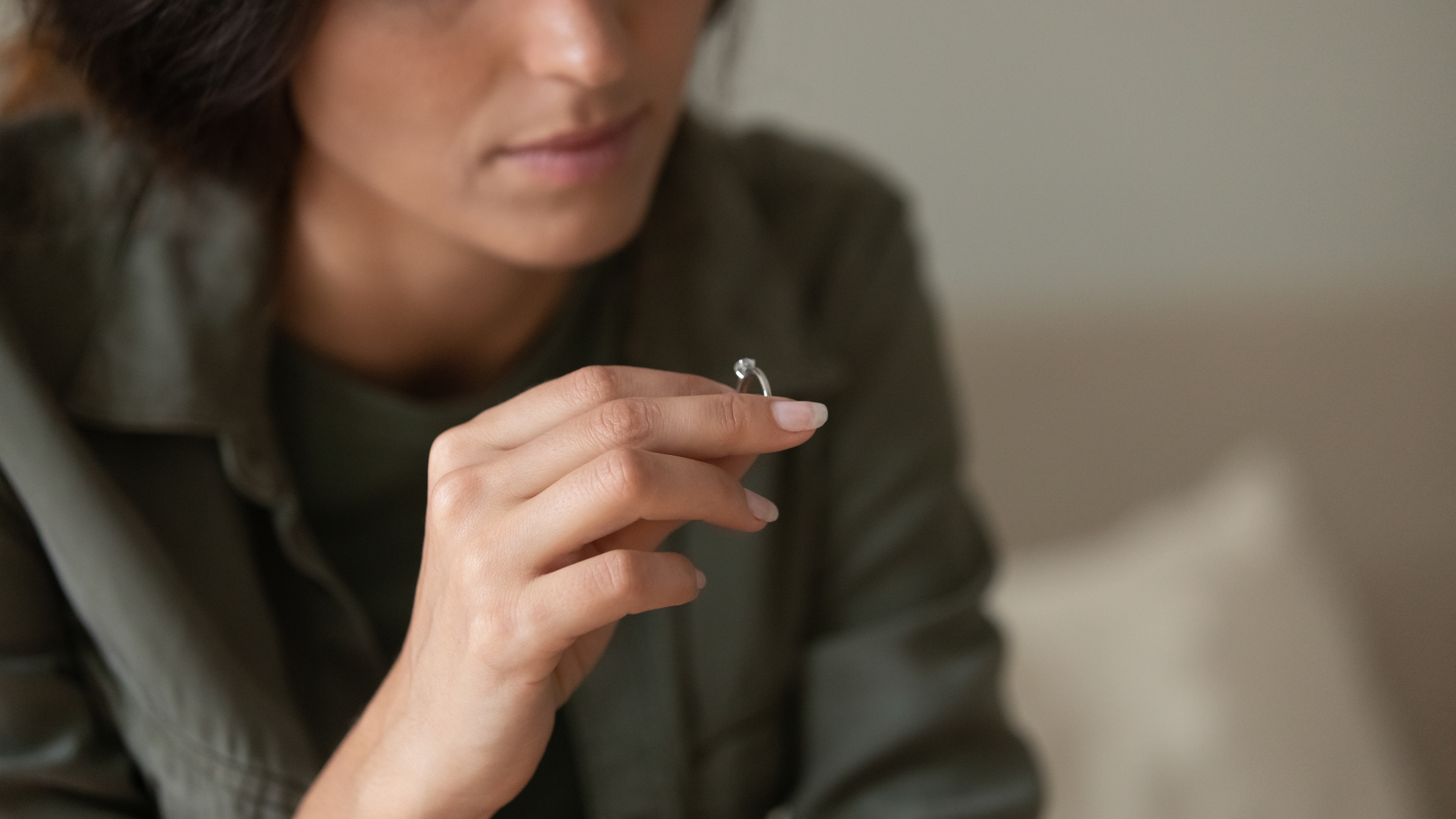 A woman looking sad while holding a ring | Source: Shutterstock