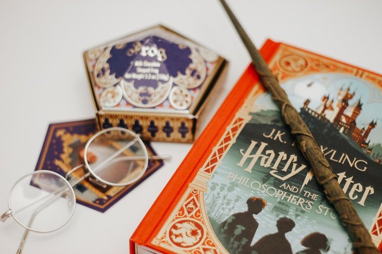 A photo of a wand and a Harry Potter book. | Photo: Unsplash