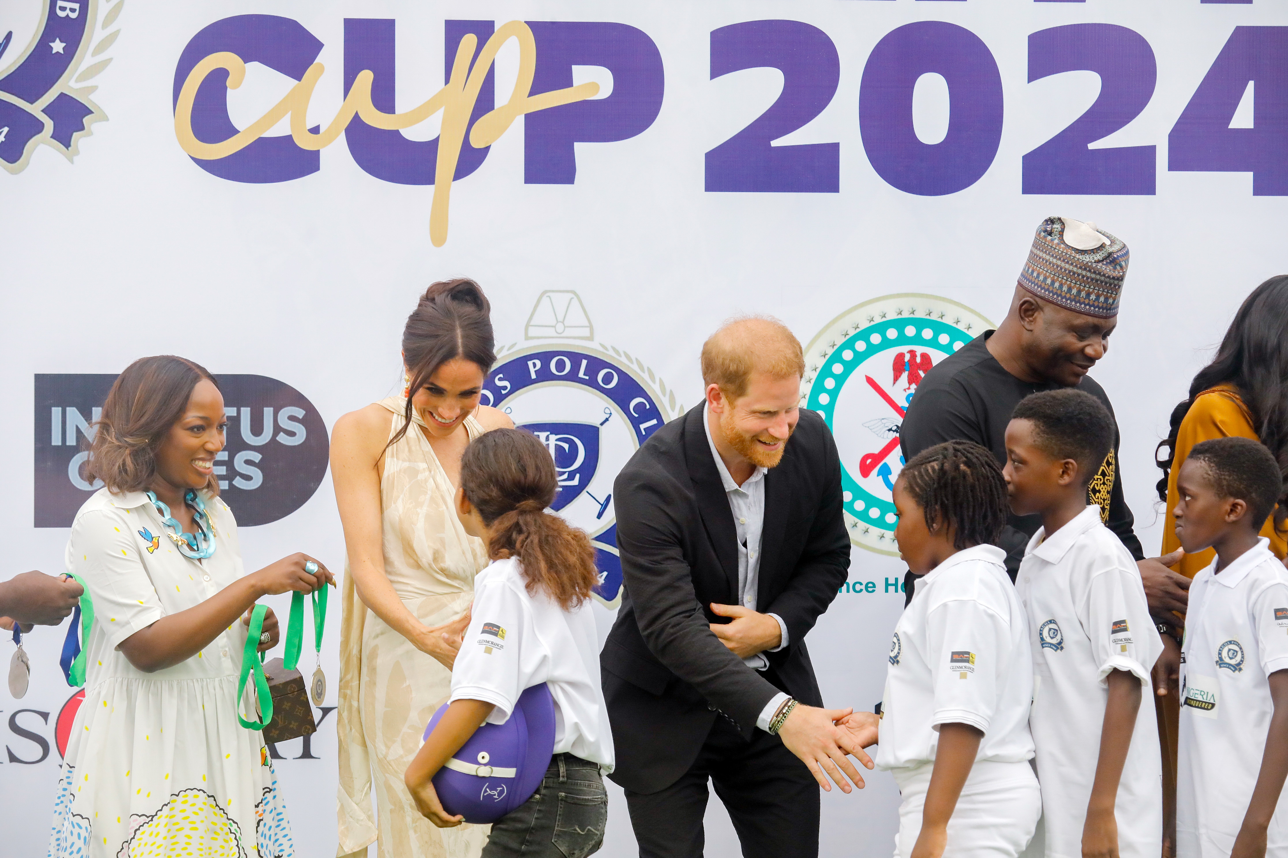 Meghan Markle and Prince Harry interacting with young girls and boys during their visit to the Polo Club in Lagos, Nigeria on May 12, 2024 | Source: Getty Images