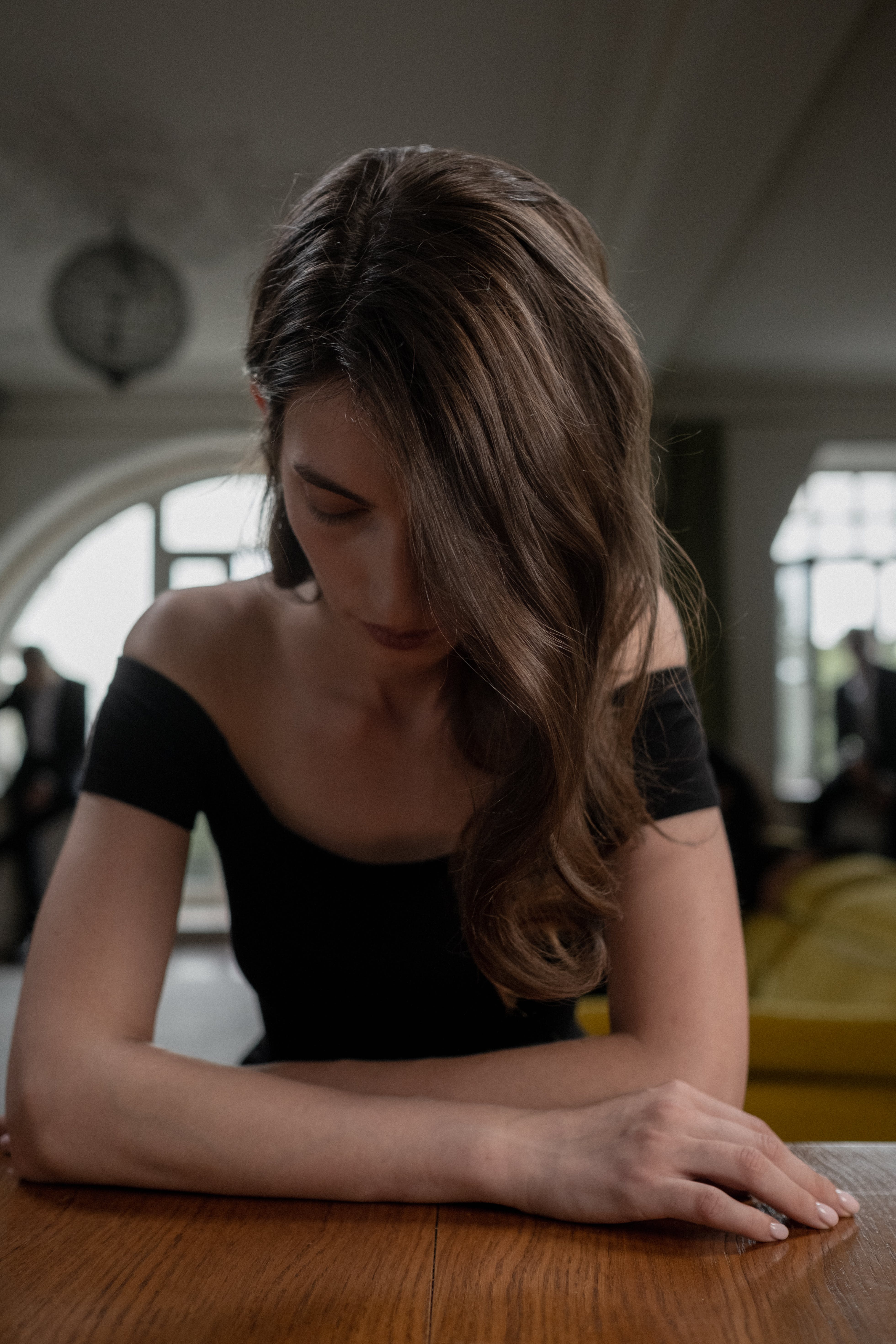 A woman sitting at a table while looking down | Source: Pexels