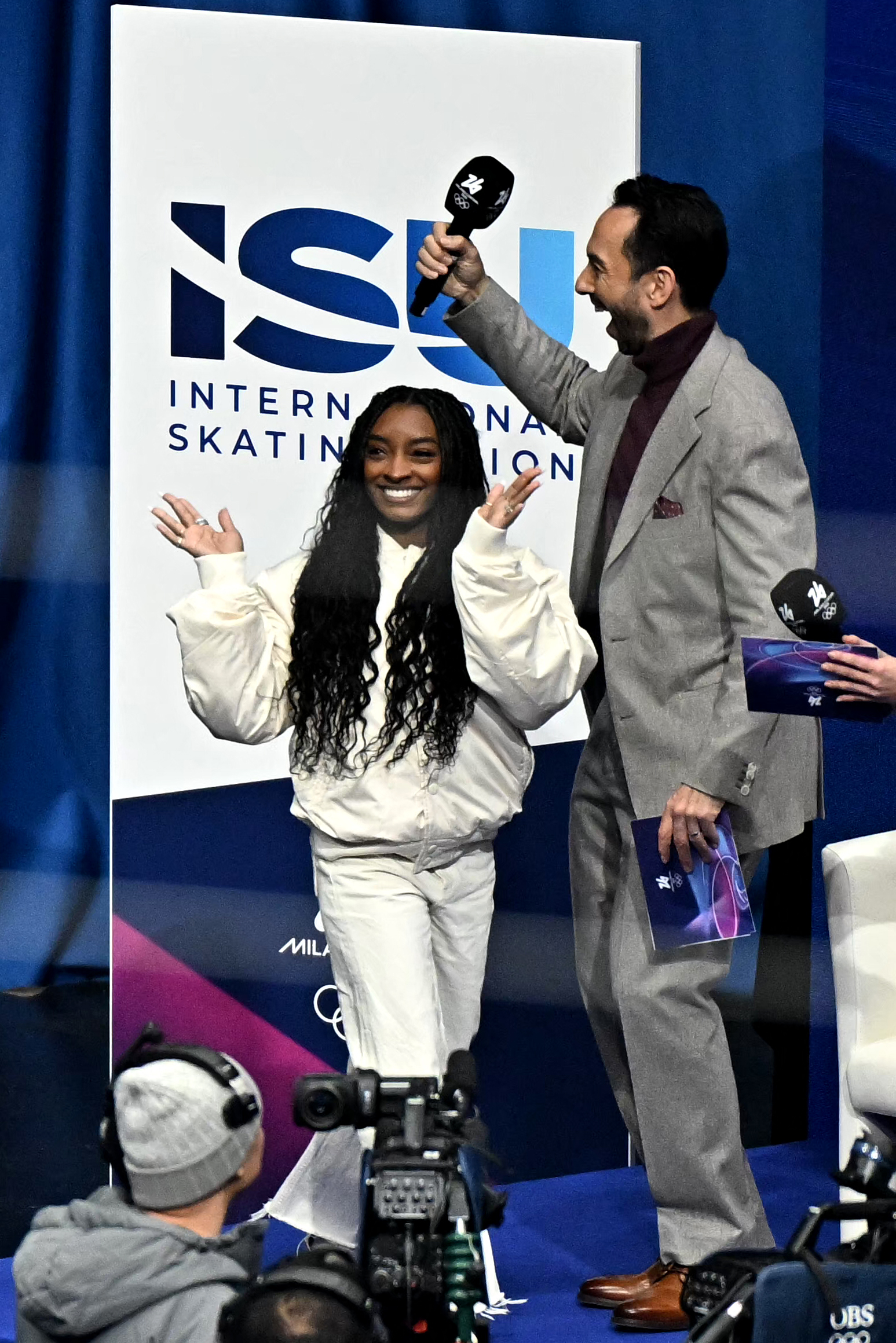 Simone Biles waves to spectators at Milano Ice Skating Arena during the figure skating men's singles free skating final at the Winter Olympic Games on February 13, 2026, in Milan, Italy | Source: Getty Images