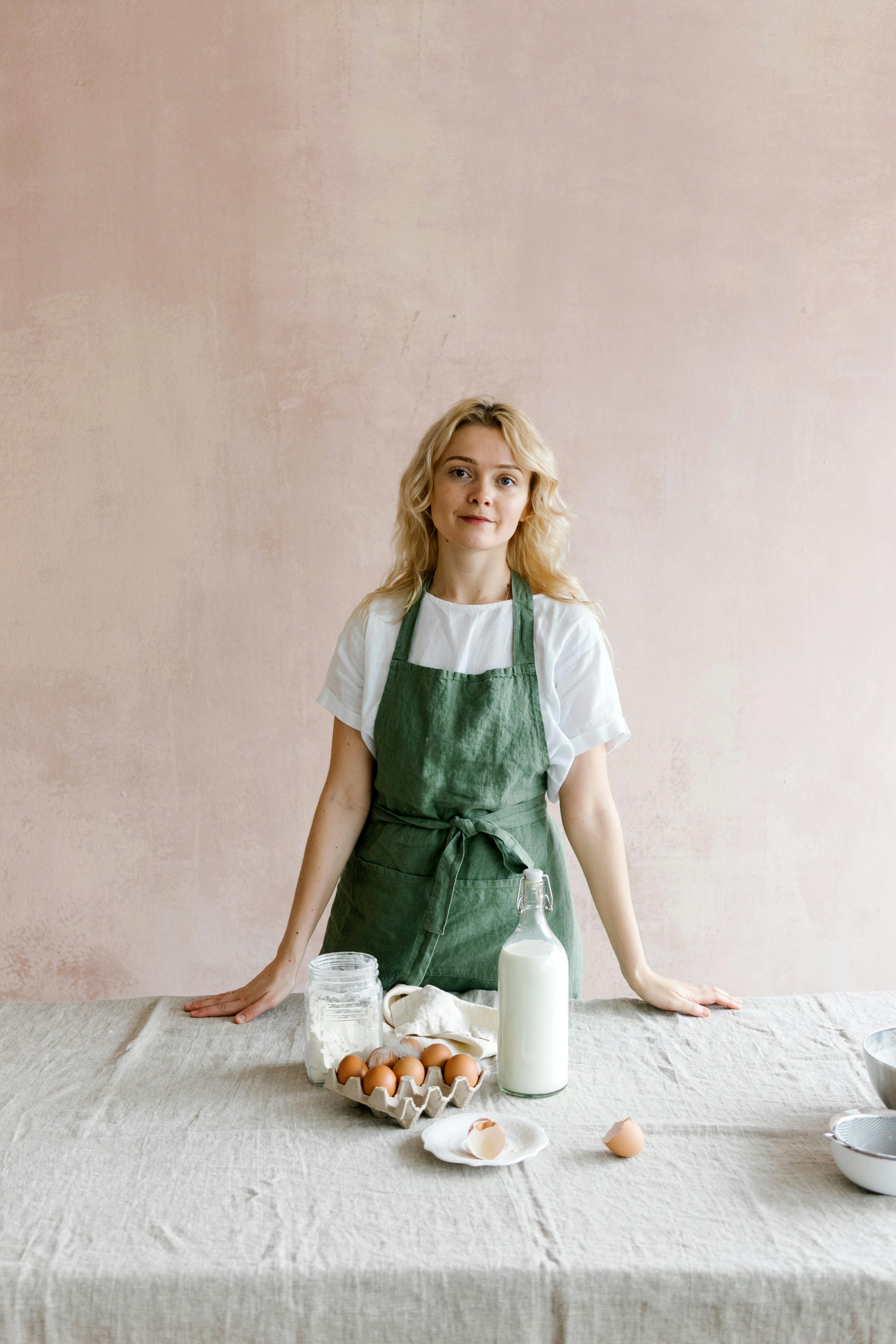 Woman in apron stands at the table cooking | Source: Pexels