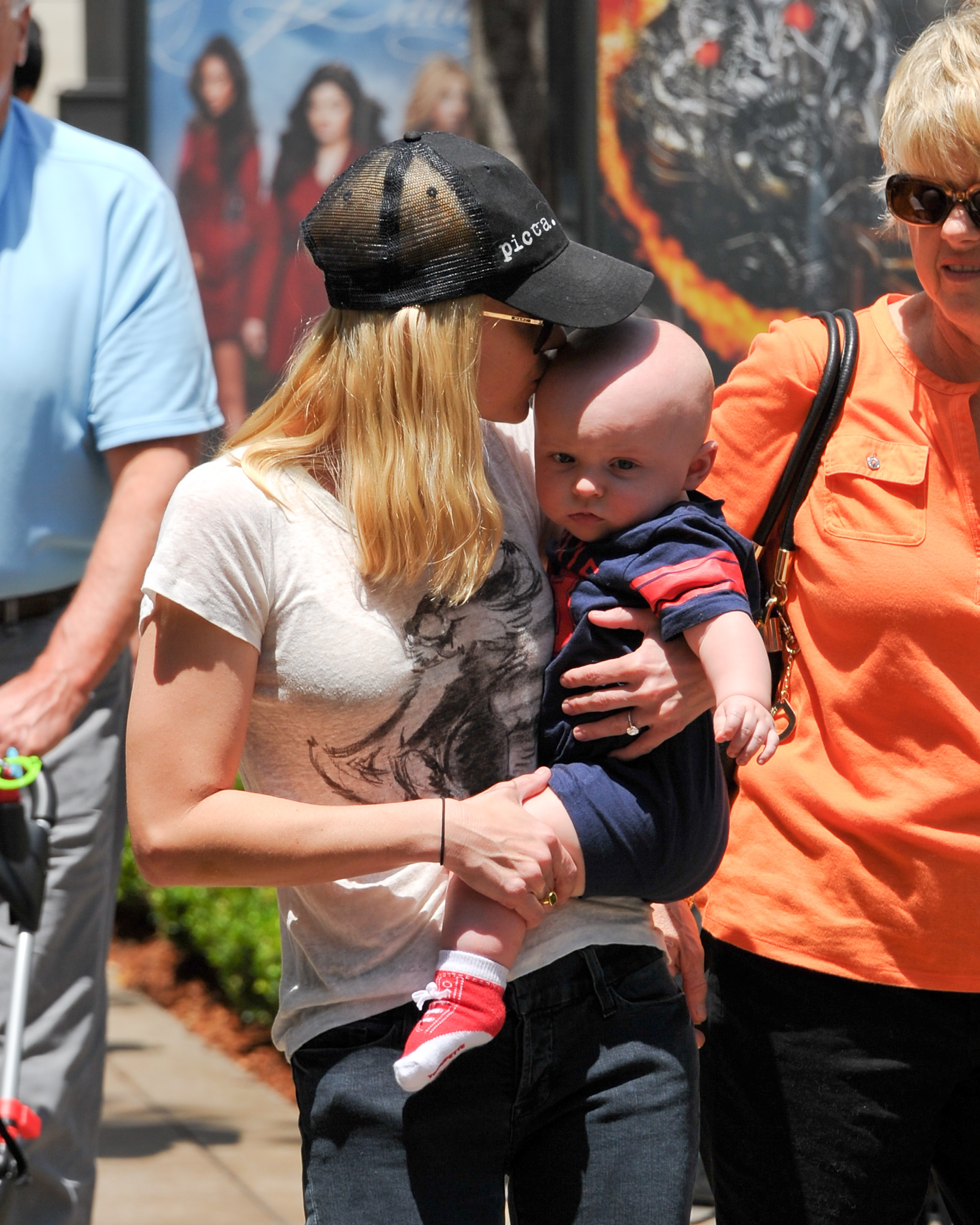 Anna Faris holds son Jack Pratt close during a sunny outing at The Grove. The actress affectionately kissed the youngster's head as the pair spent time with family and friends.