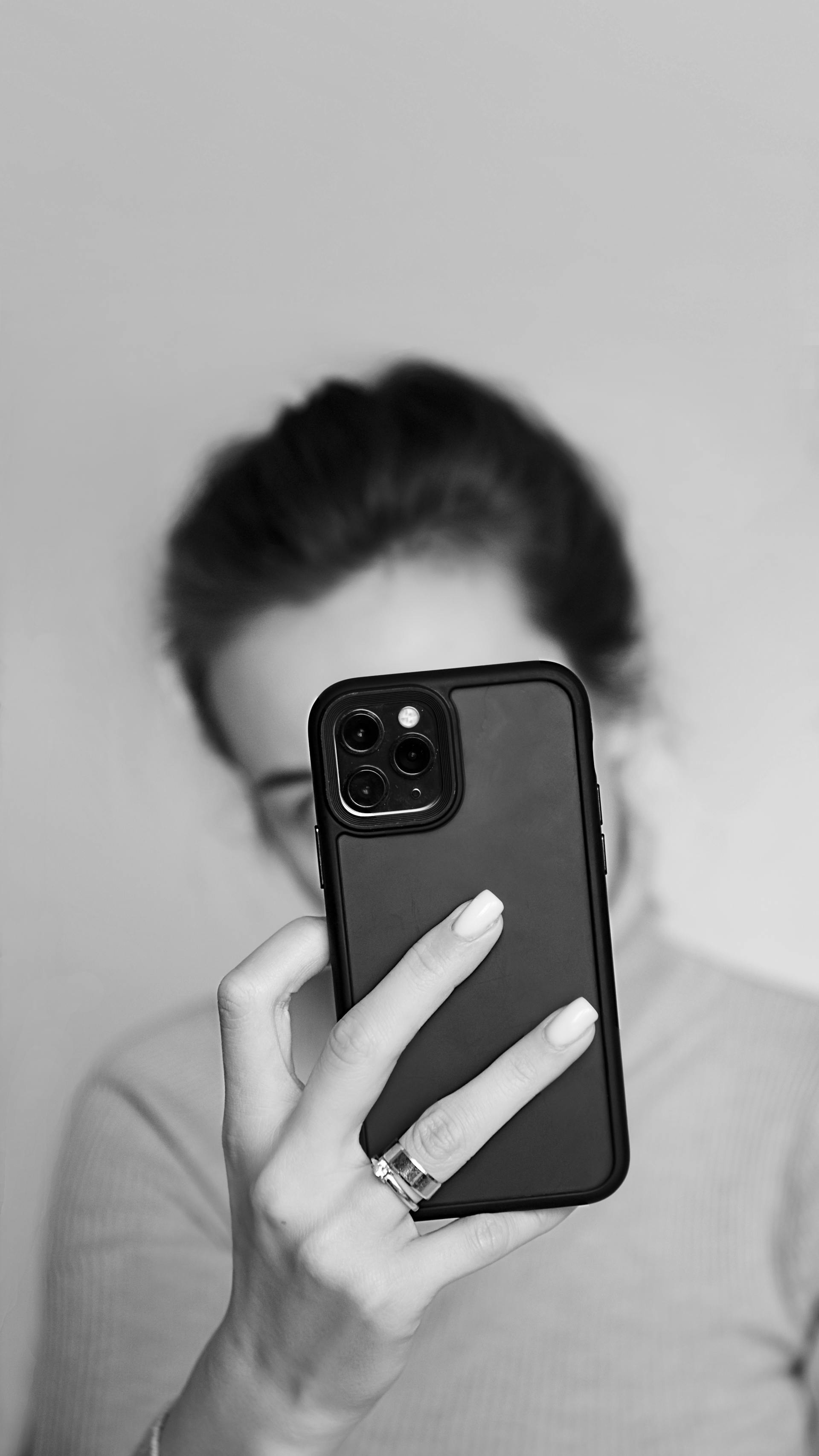 Grayscale of a woman holding a smartphone | Source: Pexels