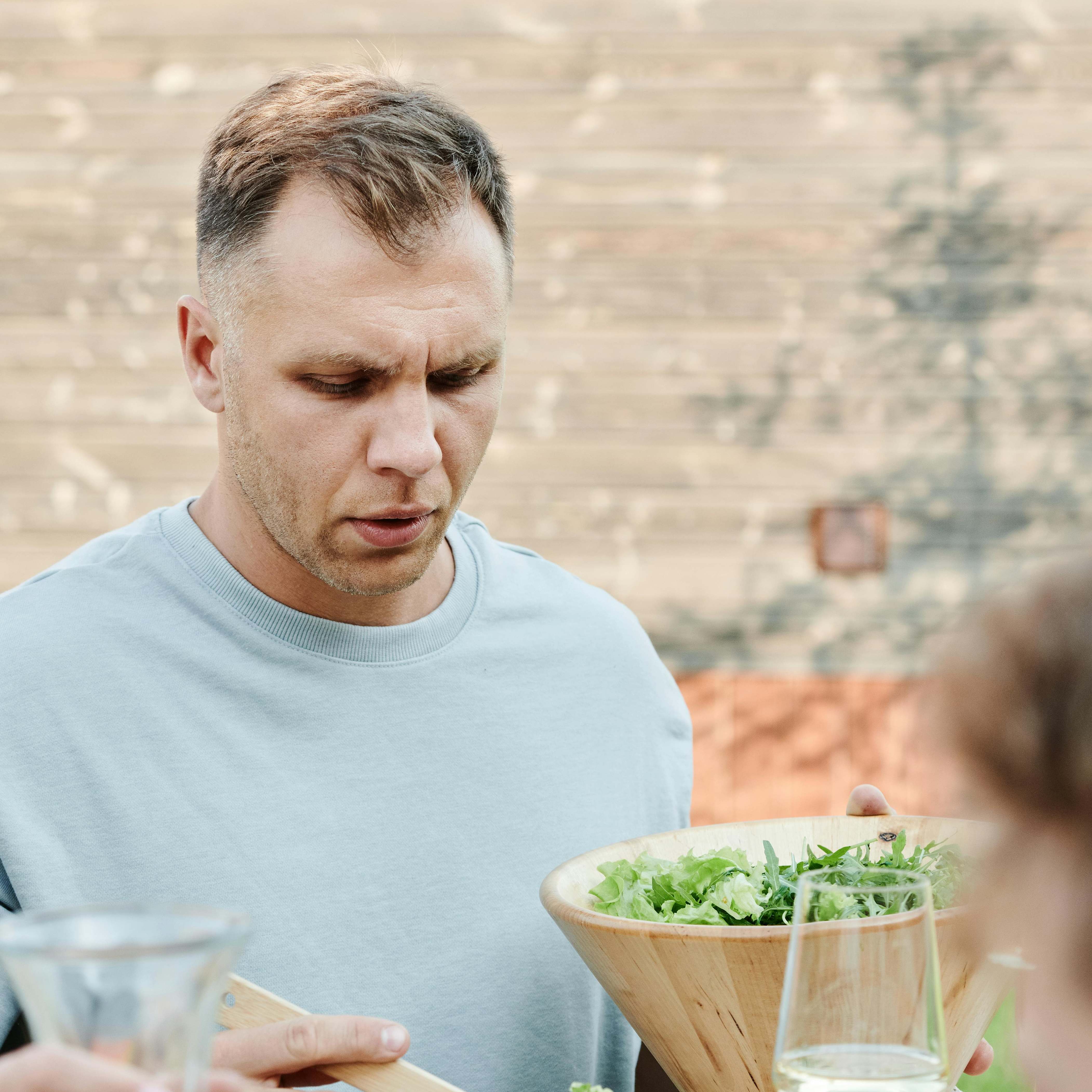 A man serving himself from a salad bowl | Source: Pexels