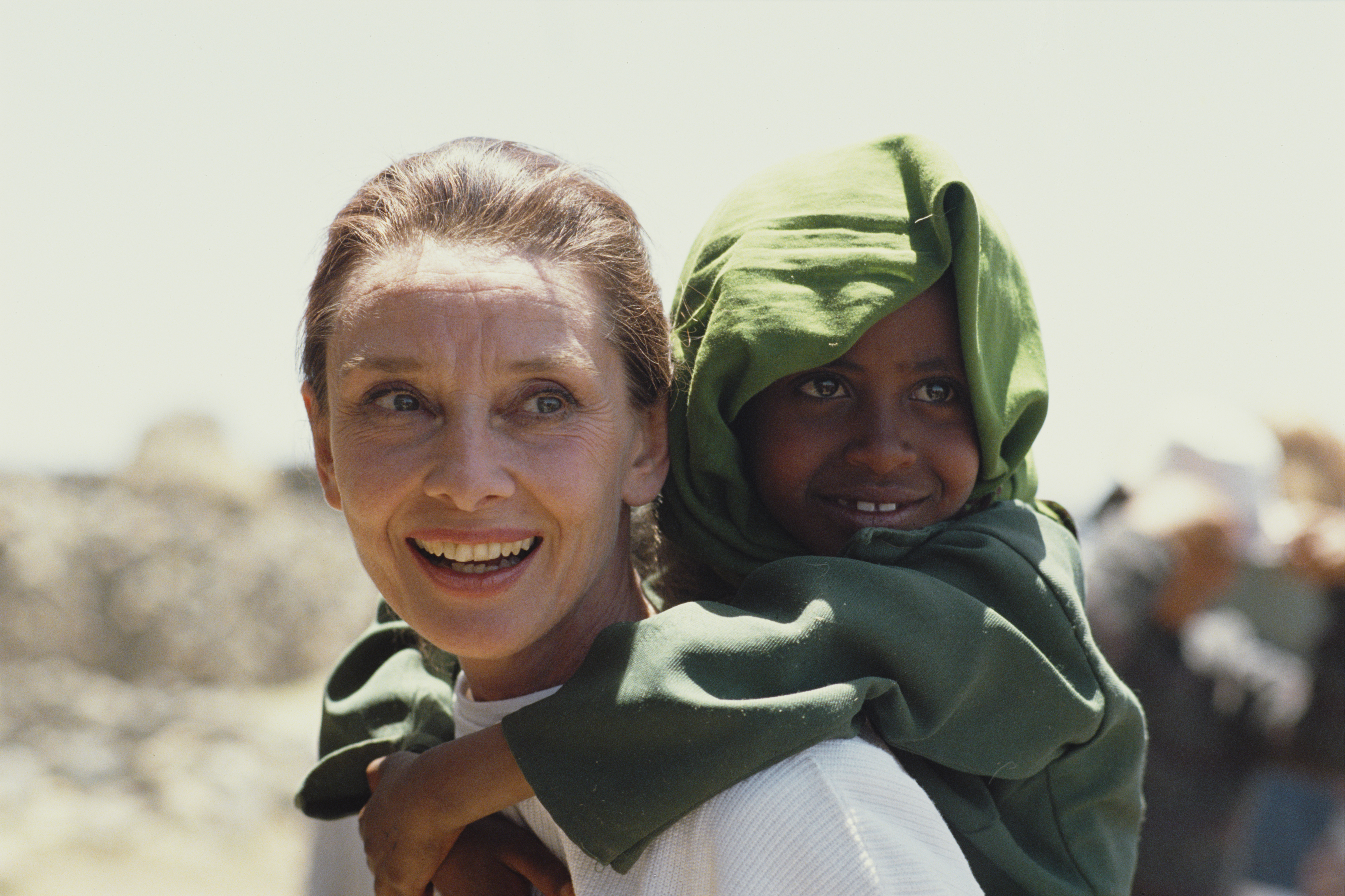 Audrey Hepburn carrying an Ethiopian girl on her back while on her first field mission for UNICEF in Ethiopia, in March 1988. | Source: Getty Images