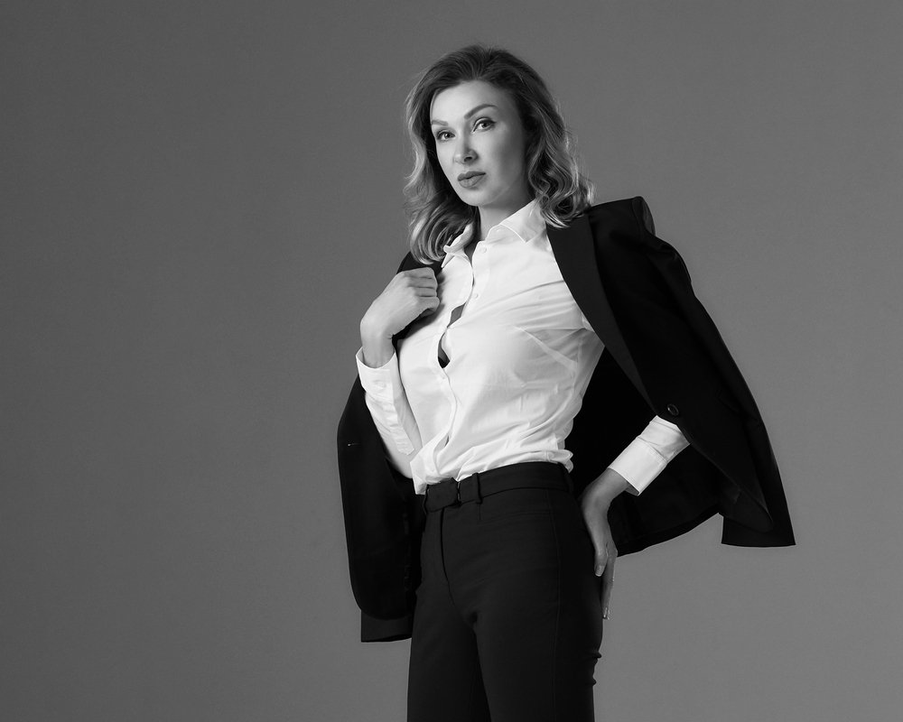 Elegante mujer con la clásica blusa blanca, pantalones de traje negro y blazer. | Foto: Shutterstock
