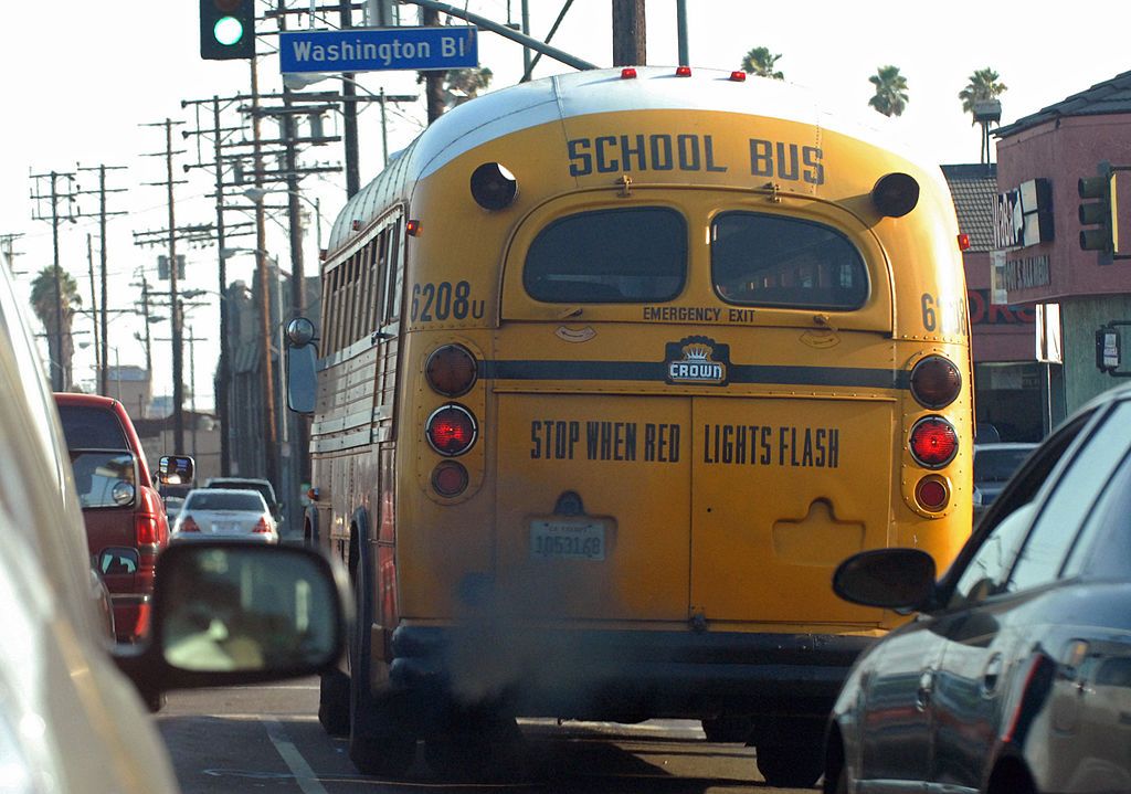 A yellow school bus driving through a busy street. | Source: Getty Images