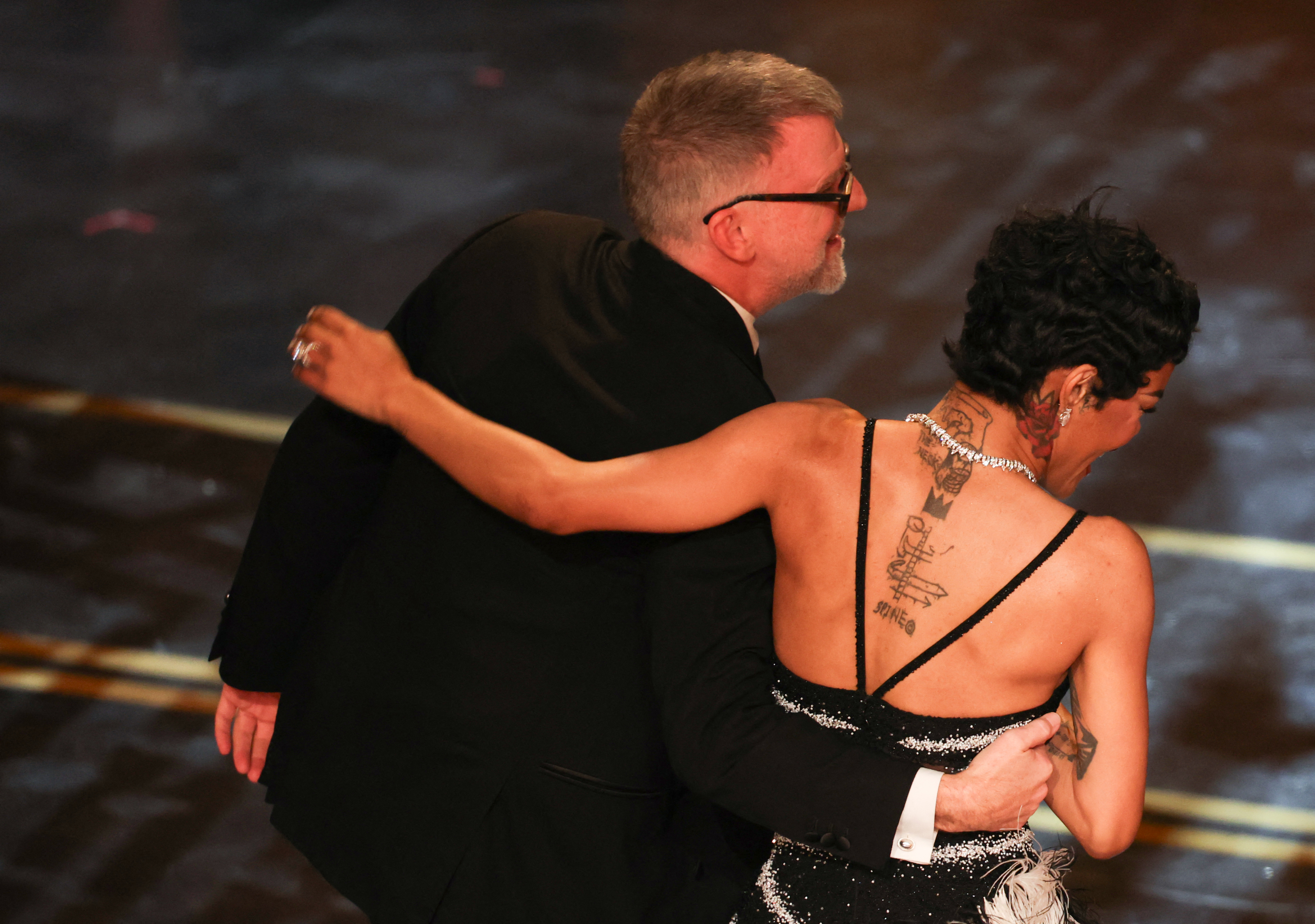 Paul Thomas Anderson and Teyana Taylor hug as they accept the award for Best Picture for "One Battle After Another" onstage during the 98th Annual Academy Award. | Source: Getty Images
