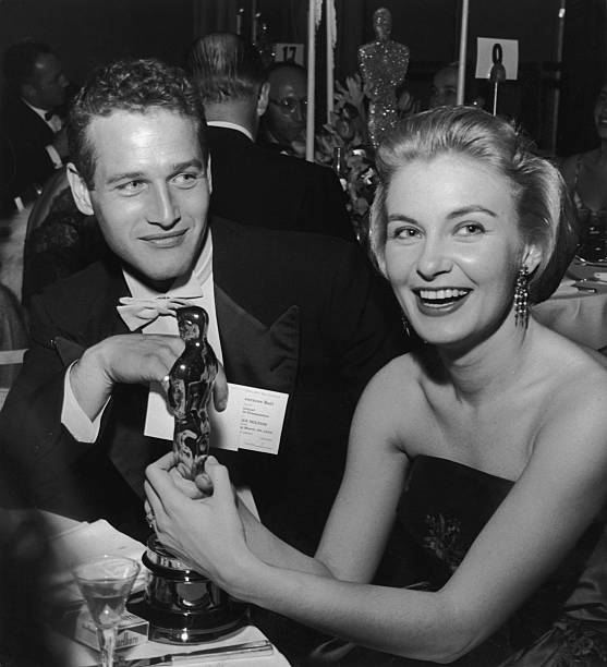 Joanne Woodward hält ihre Oscar-Statuette, während sie neben Ehemann Paul Newman sitzt, während des Governor's Ball, einer Oscar-Party im Beverly Hilton Hotel, Beverly Hills, Kalifornien | Quelle: Getty Images