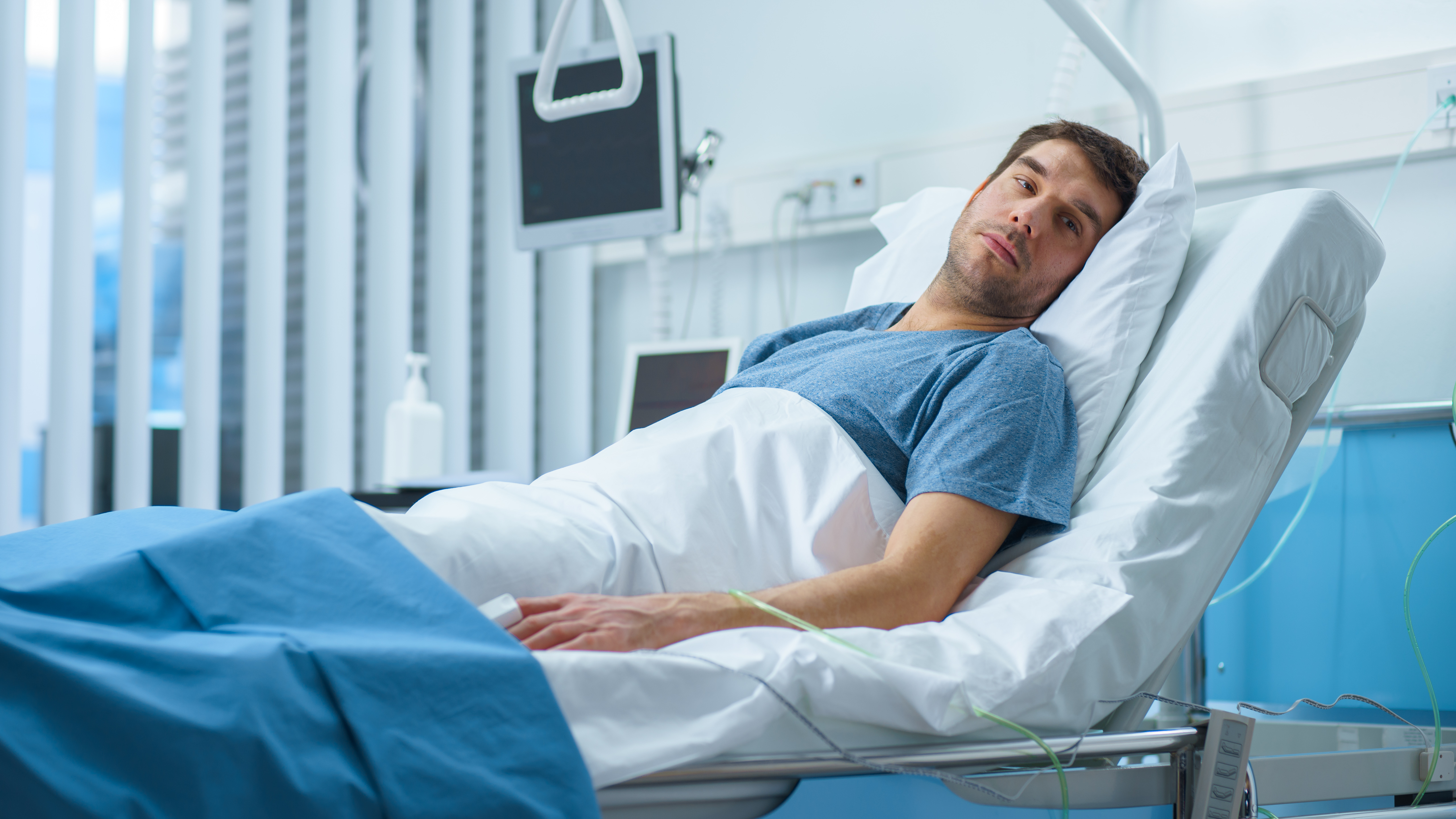 A male patient is seen lying in a hospital bed | Source: Shutterstock