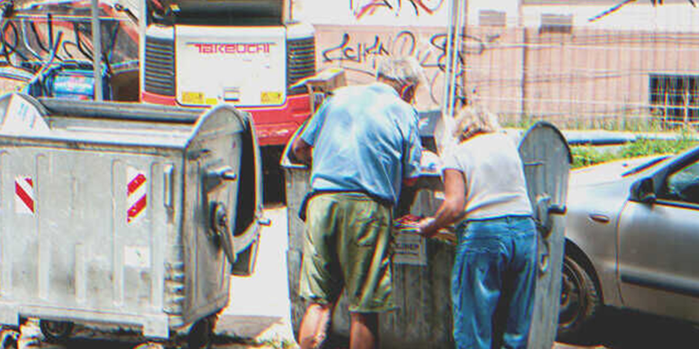 Two persons digging through a dumpster | Source: Shutterstock