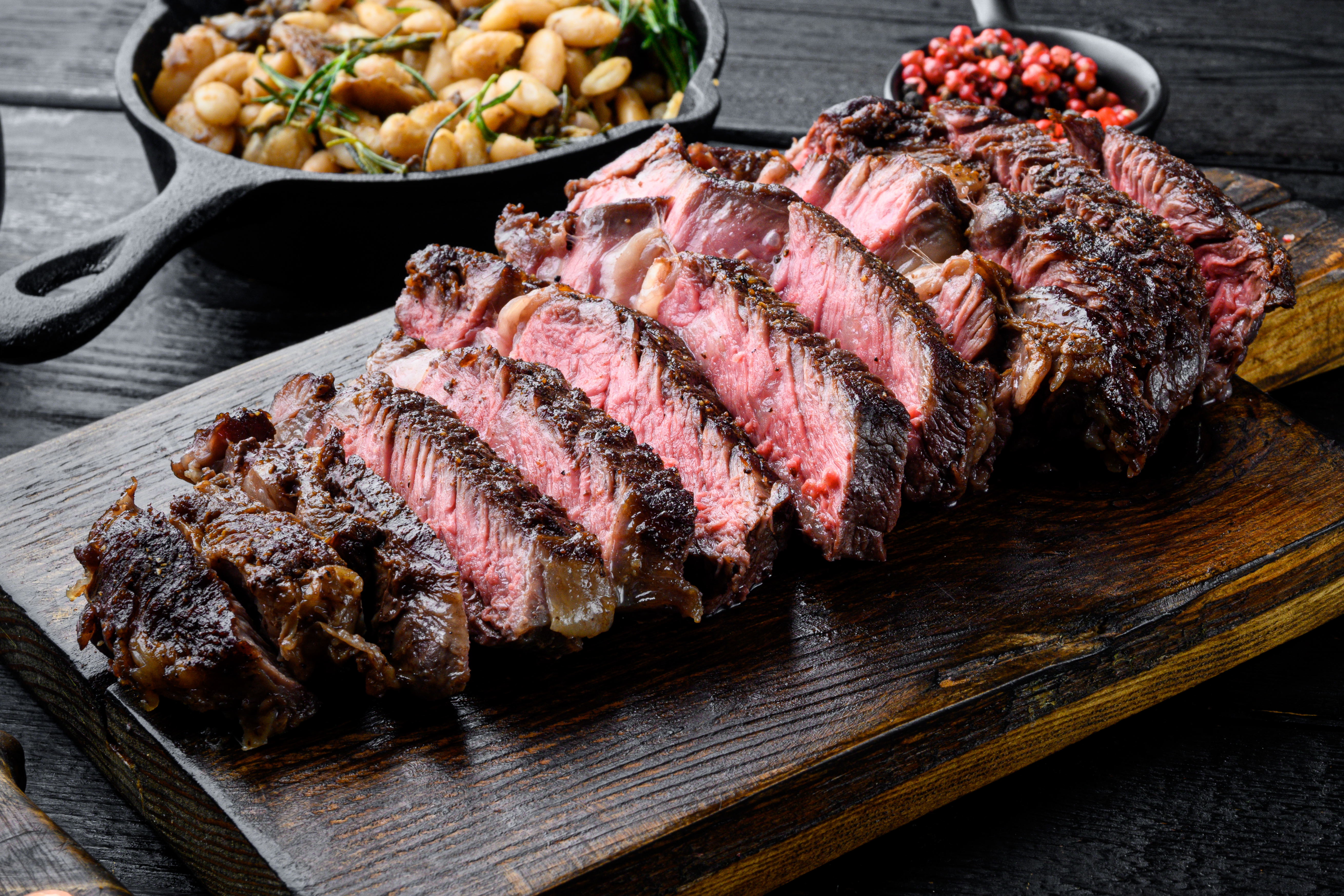 Sliced grilled meat steak Rib eye medium rare set, on wooden serving board. | Source: Shutterstock