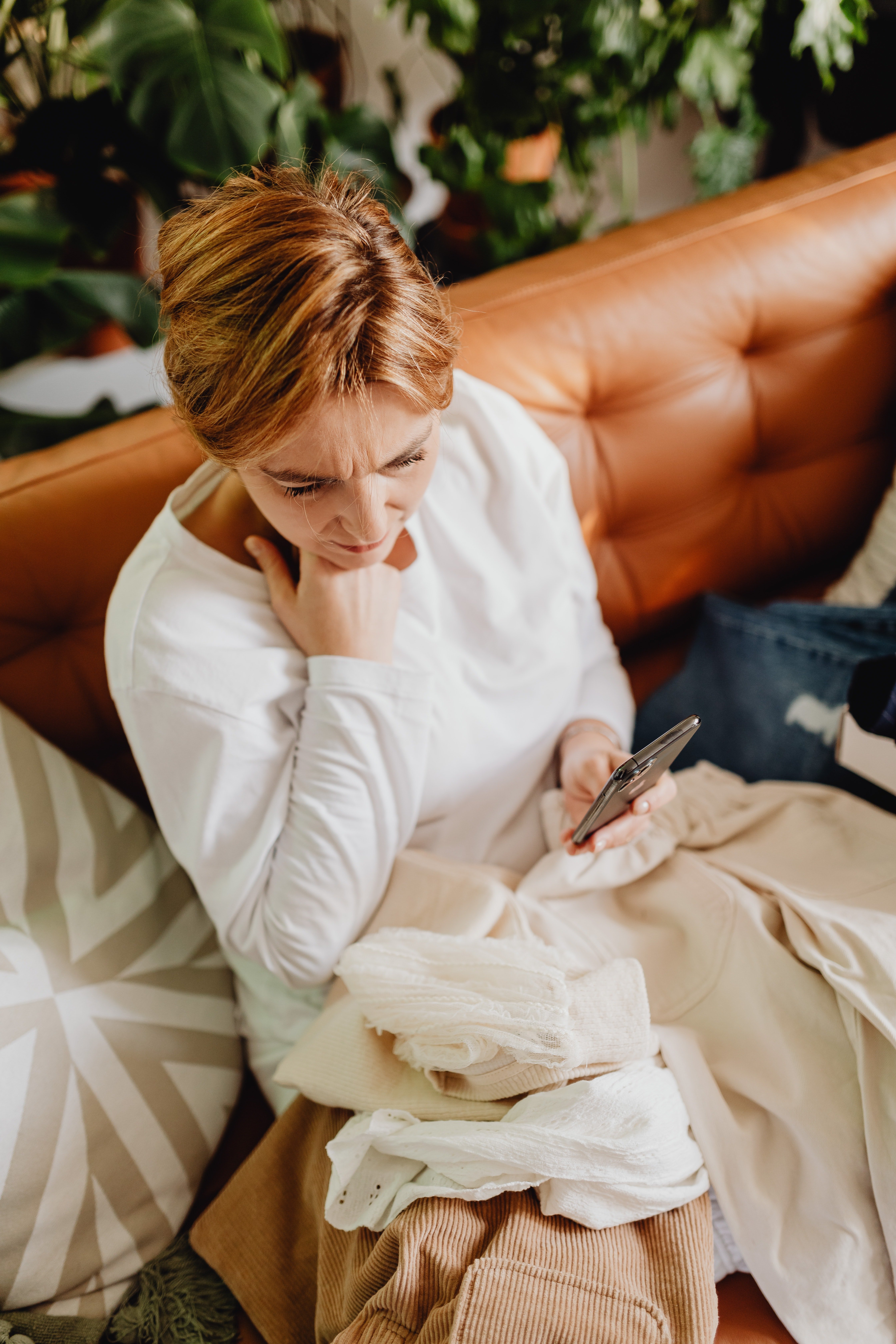 A distraught-looking woman pictured with a phone in her hand. | Source: Pexels