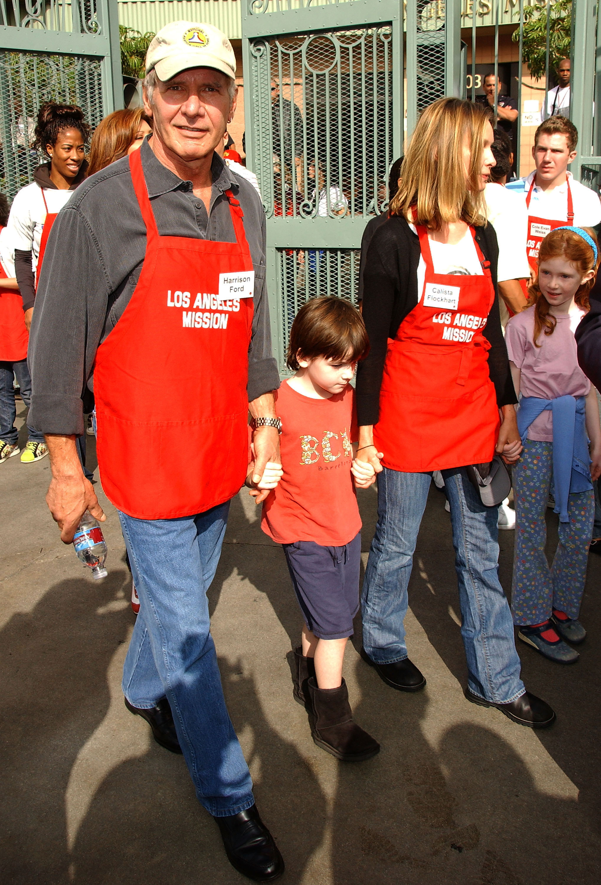 Harrison Ford and Calista Flockhart with son Liam participate in serving Thanksgiving dinner to the Skid Row homeless at the Los Angeles Mission in Downtown Los Angeles, California, on November 21, 2007 | Source: Getty Images