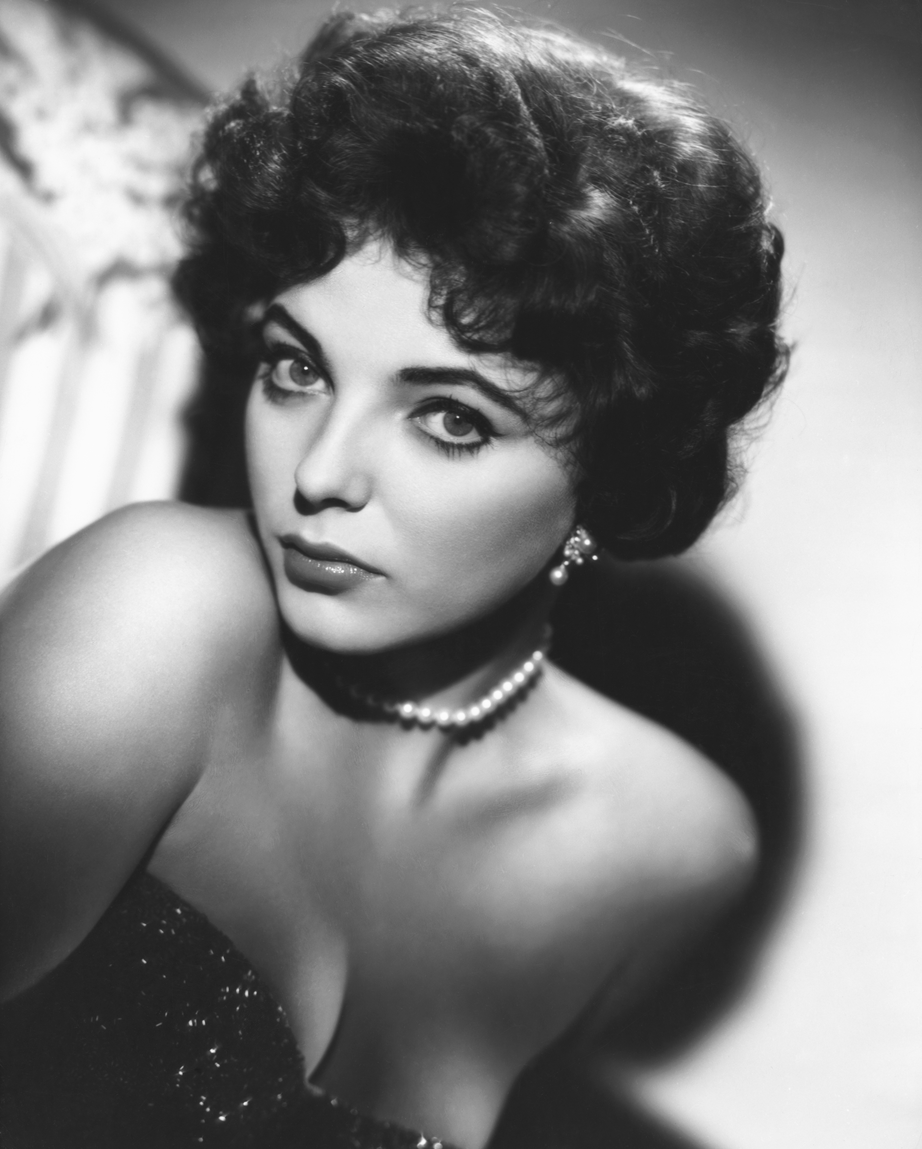 Joan Collins posing in a black-and-white photo in 1957 | Source: Getty Images