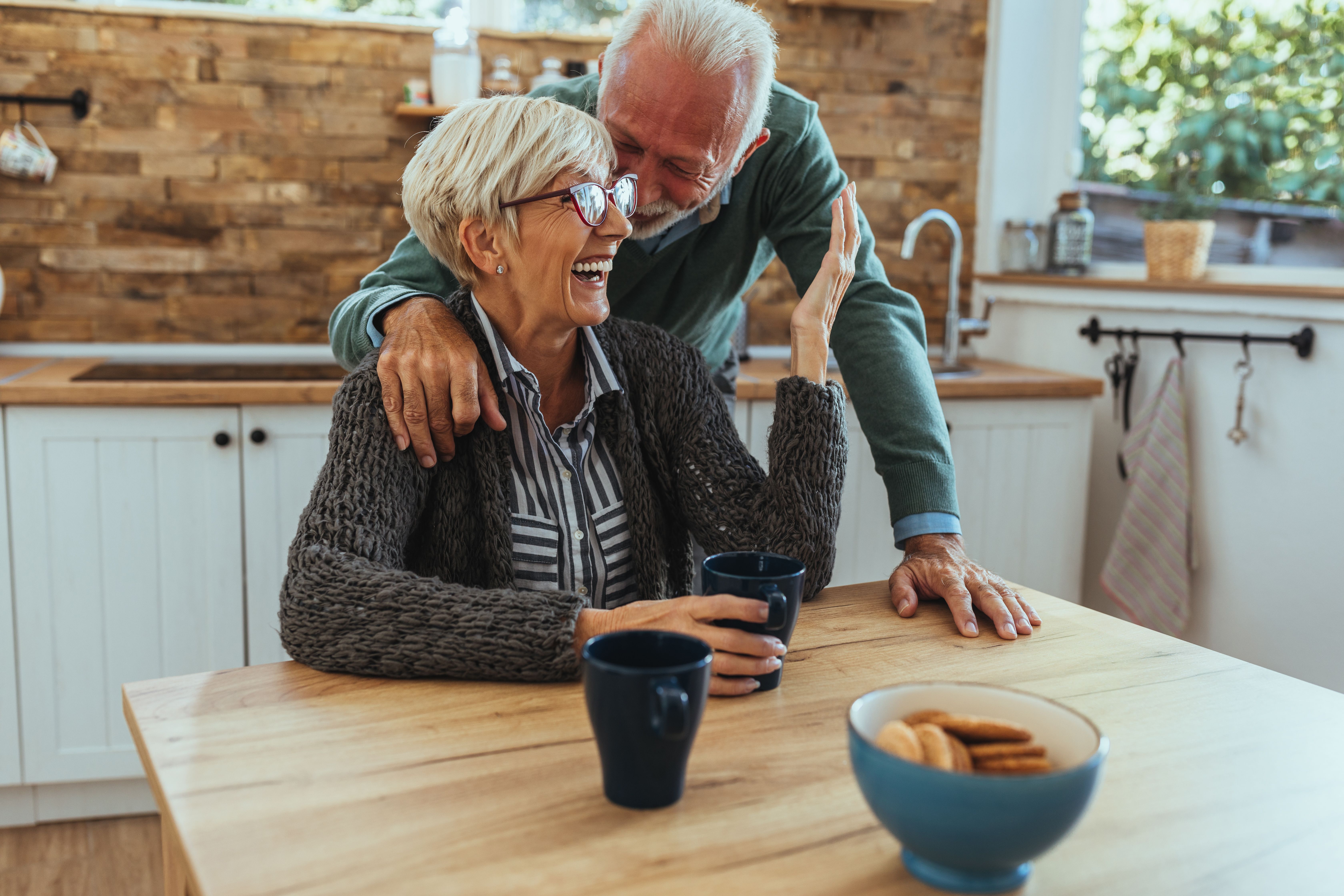 An elder couple smiling in the kitchen. | Source: Shutterstock