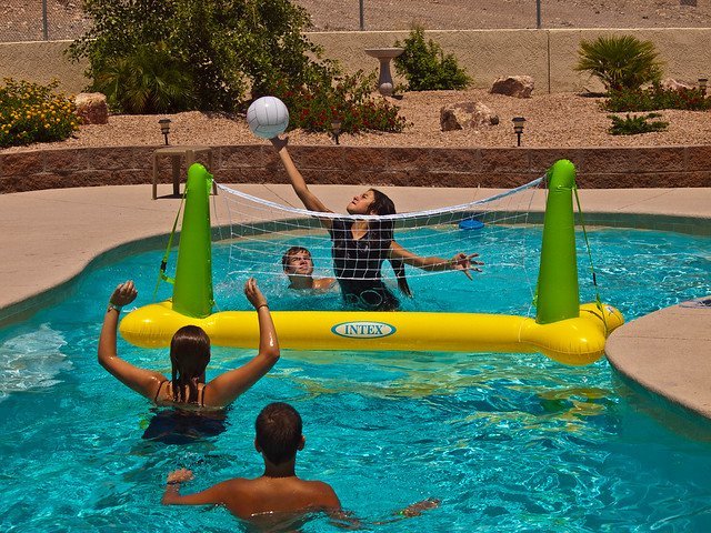 People enjoying a game of pool volleyball. | Photo: Flickr