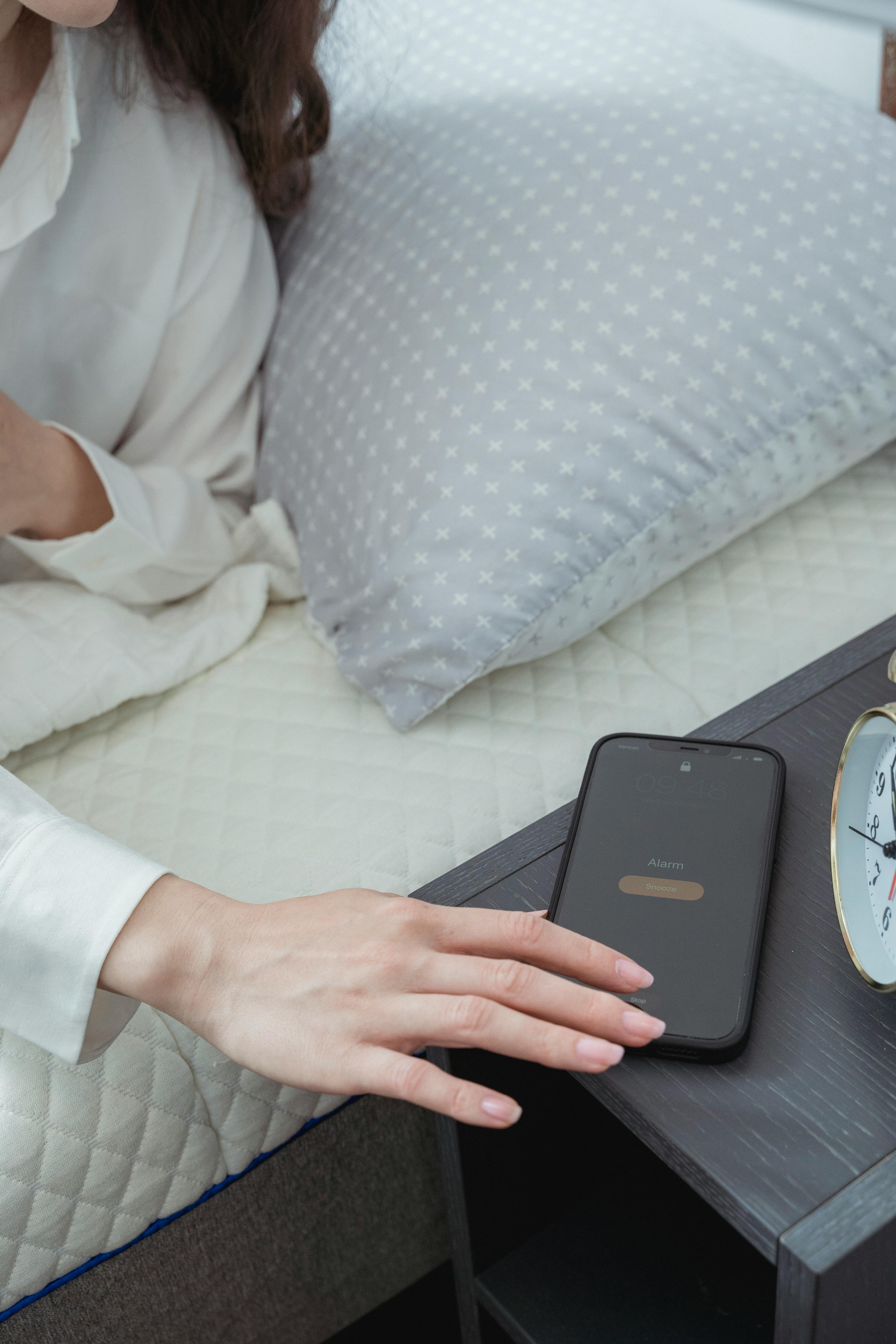 A woman about to turn off her alarm | Source: Pexels
