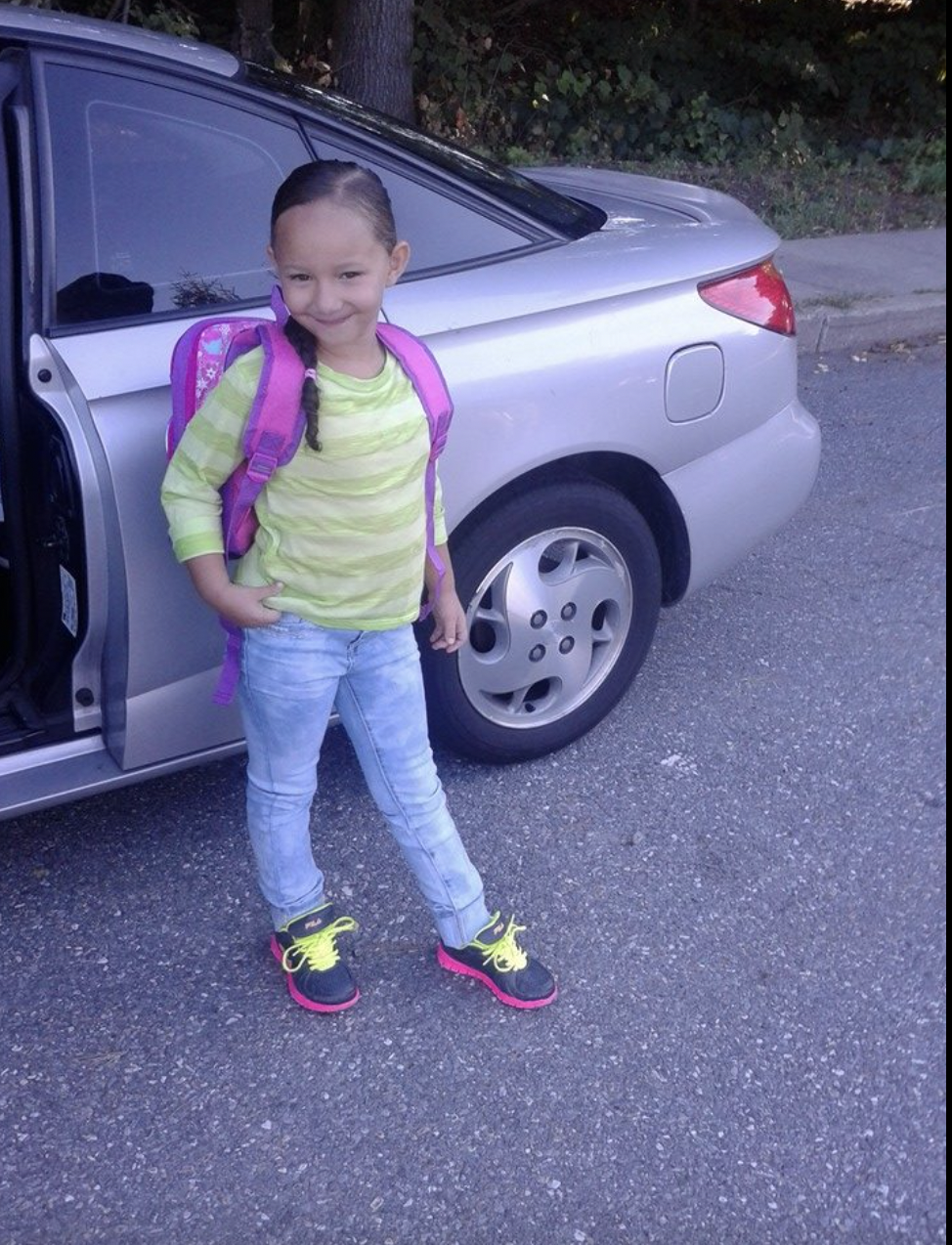 A young Ahliana Dickey standing next to a car wearing a backpack, as seen in a photo dated September 8, 2014 | Source: Facebook/stephanie.wetherbee