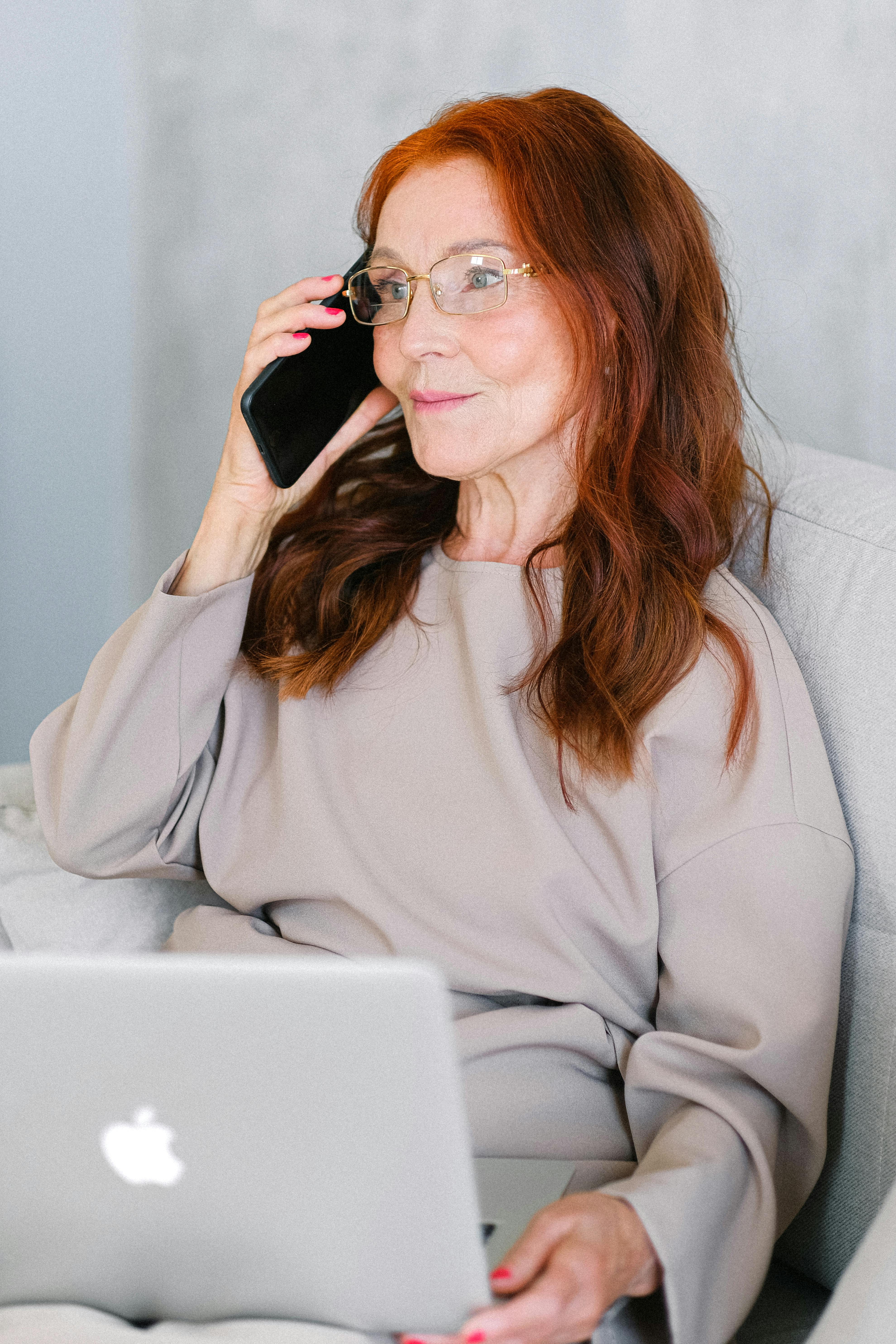 Elderly woman trying to keep calm on the phone | Source: Pexels