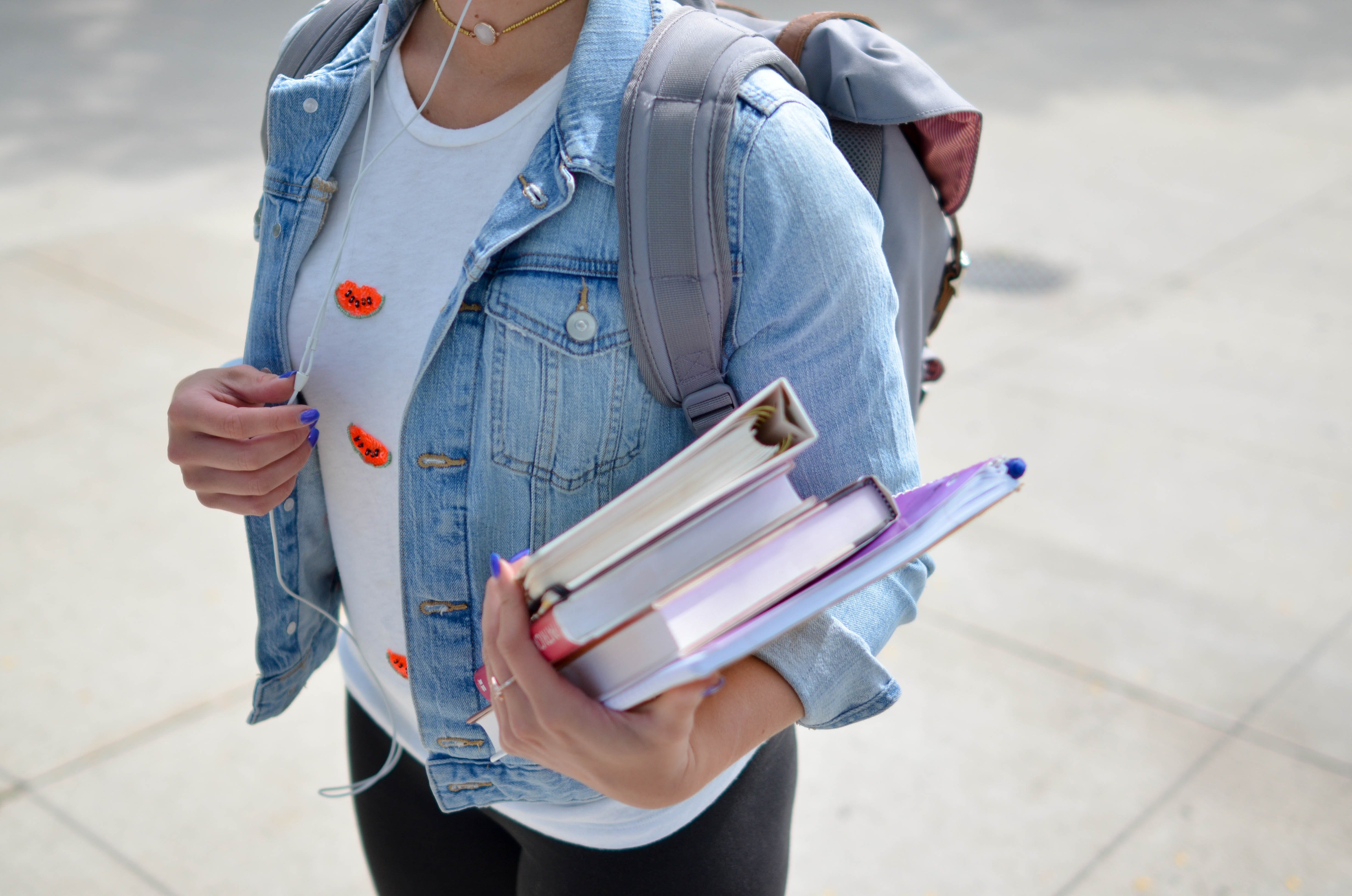 Girl carrying books and a backpack | Photo: Unsplash