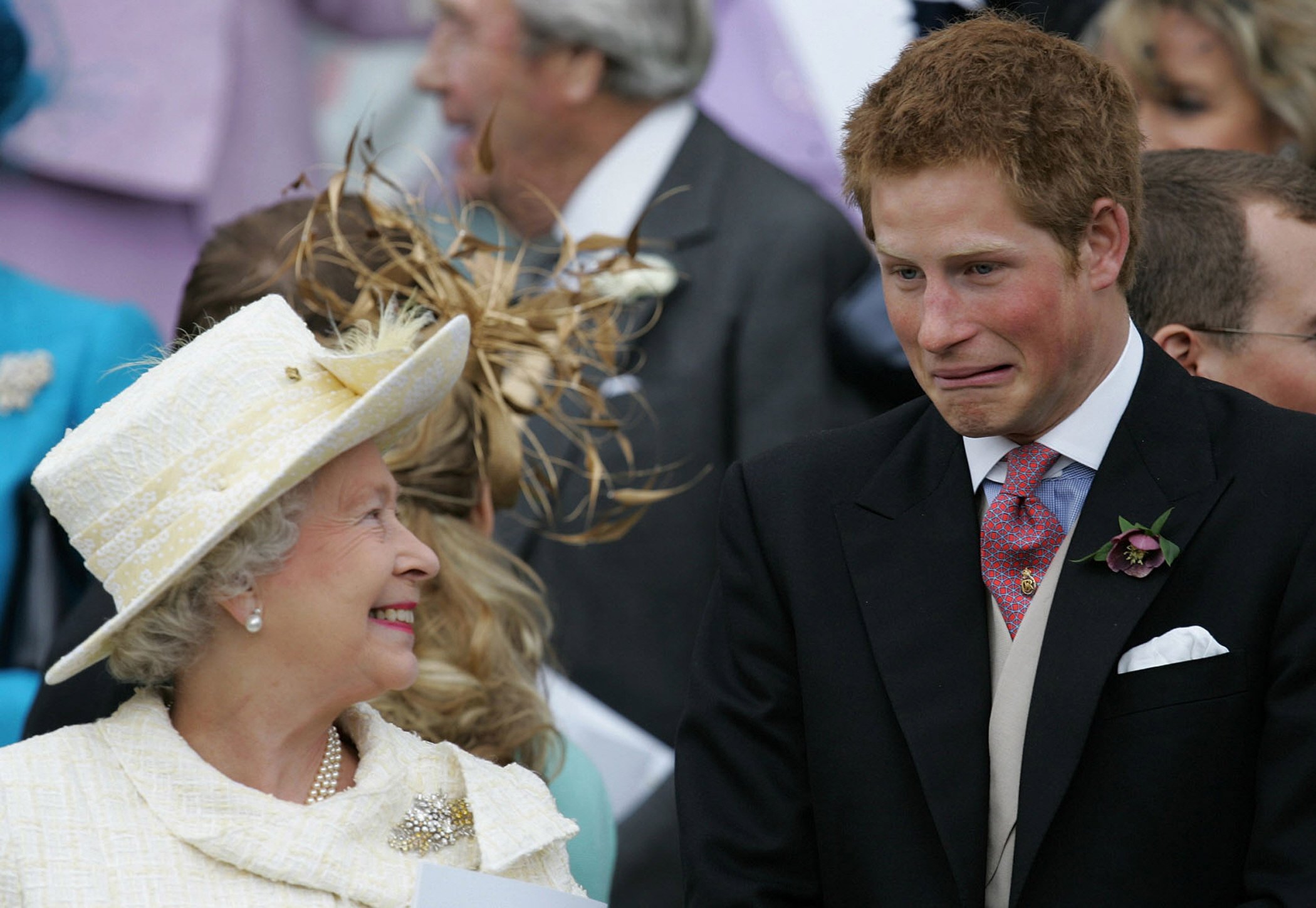 Königin Elizabeth II. und ihr Enkel Prinz Harry sehen zu, wie Prinz Charles und Camilla, Herzogin von Cornwall, nach ihrem Ehesegen am 9. April 2005 in Windsor, Großbritannien, die St. George's Chapel verlassen┃Quelle: Getty Images