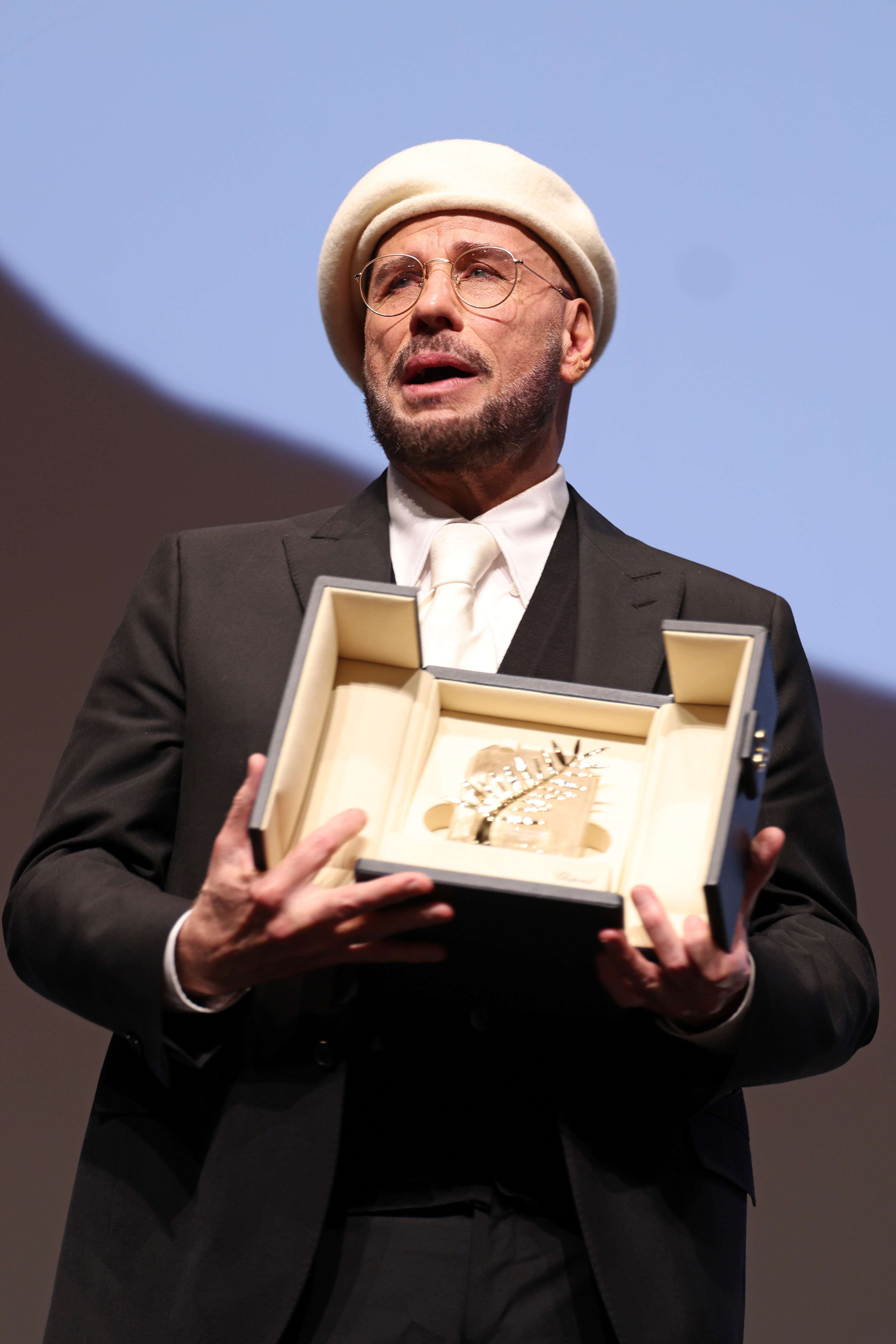 John Travolta accepts the Honorary Palme Award onstage during the annual Cannes Film Festival at Plage Macé on May 15, 2026, in Cannes, France | Source: Getty Images