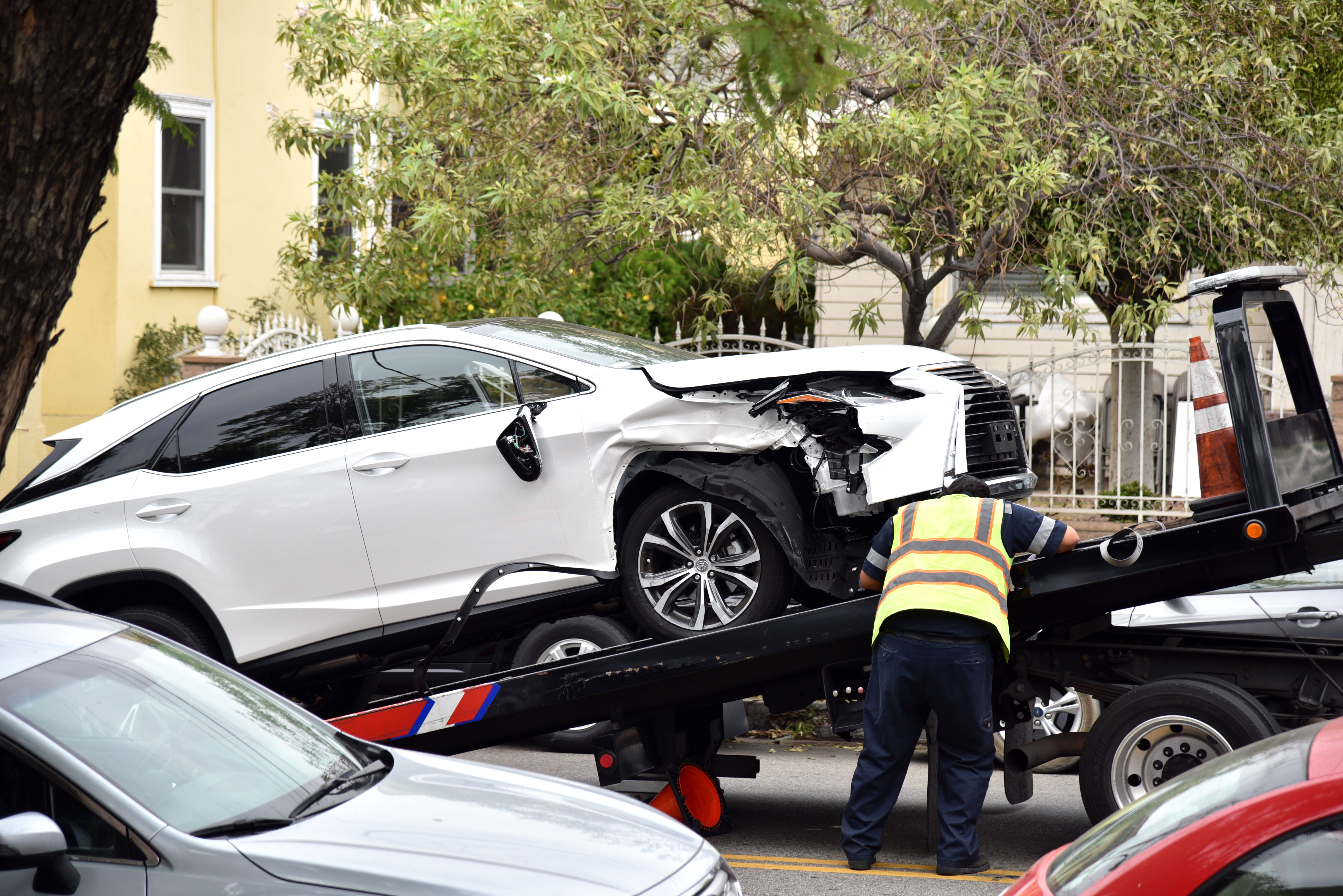 A tow truck driver towing a damaged car. | Source: Shutterstock