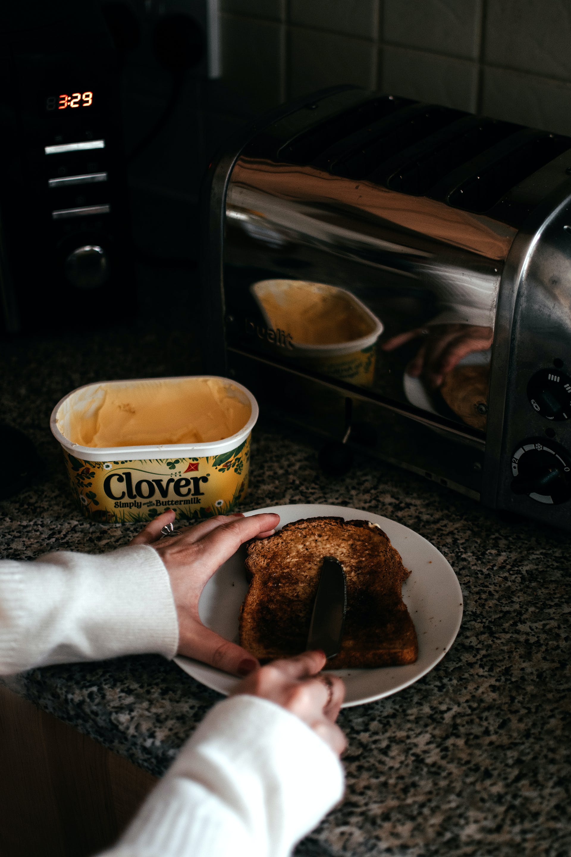 Person spreading butter on toast | Source: Pexels