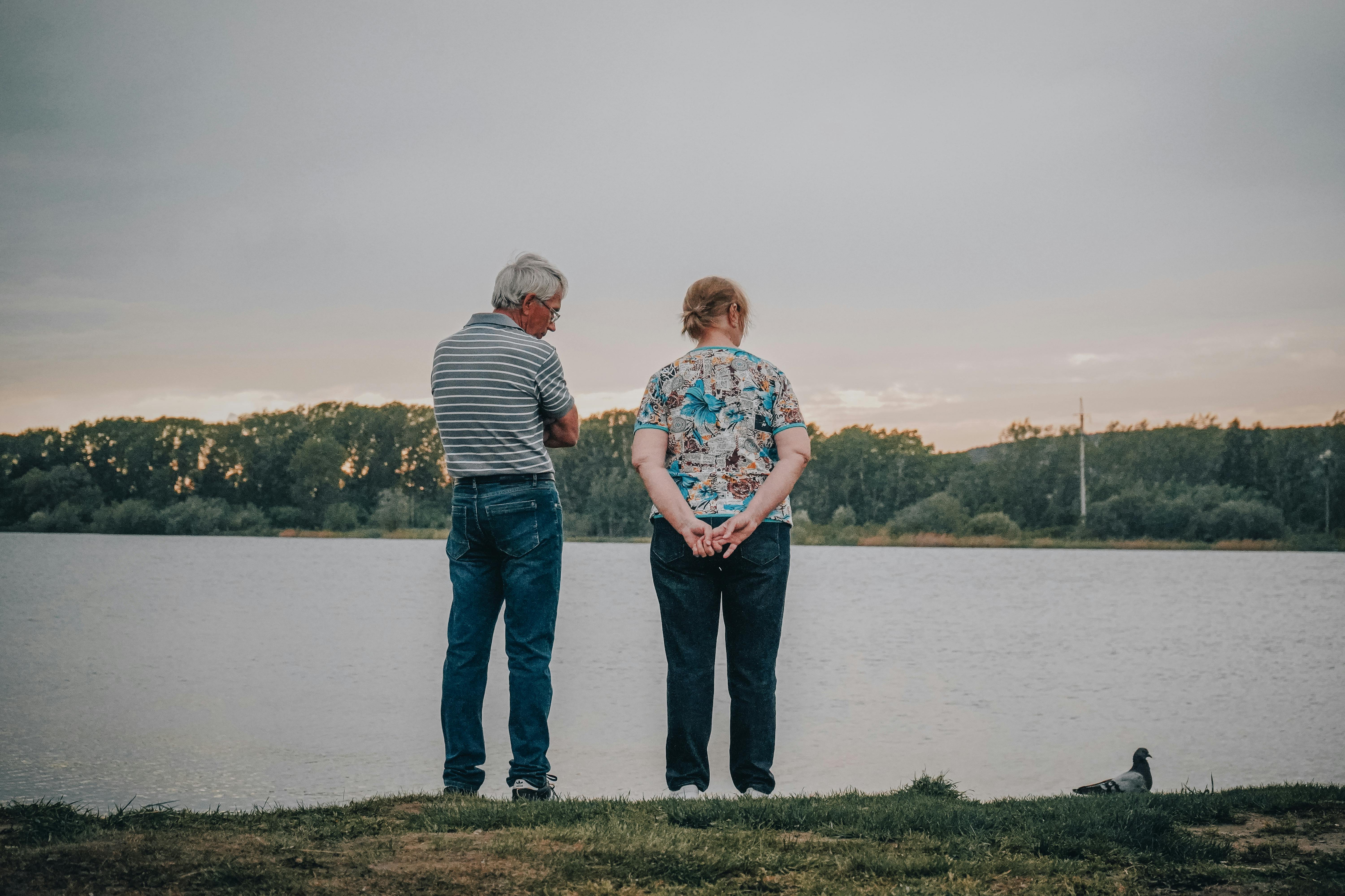 An elderly couple standing by a lake | Source: Pexels