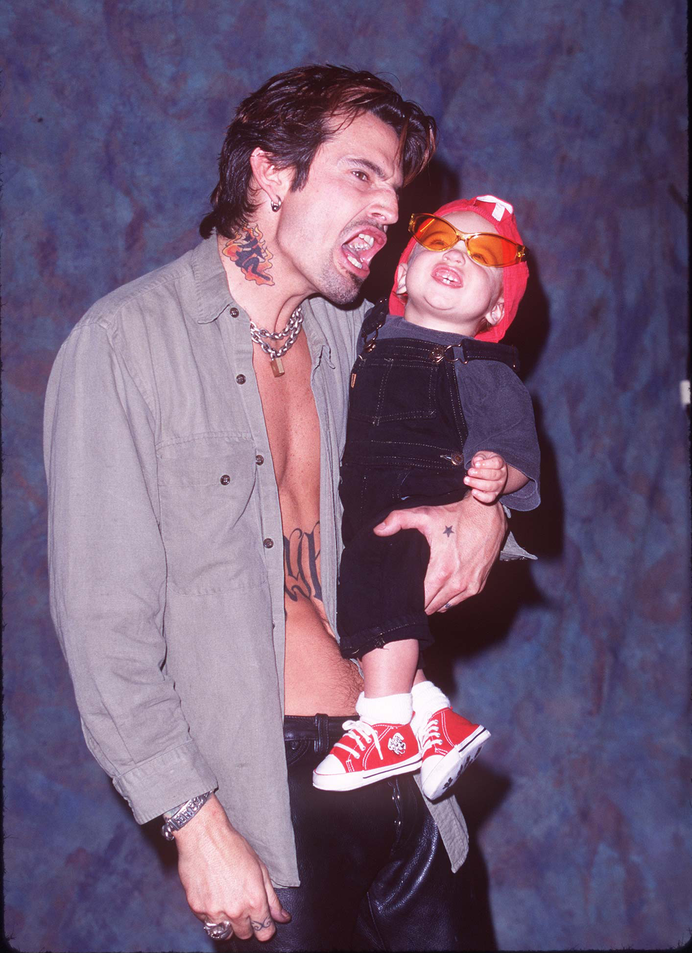 Tommy Lee reacts while holding his son Brandon at Guitar Center in Hollywood, California, on May 20, 1997 | Source: Getty Images