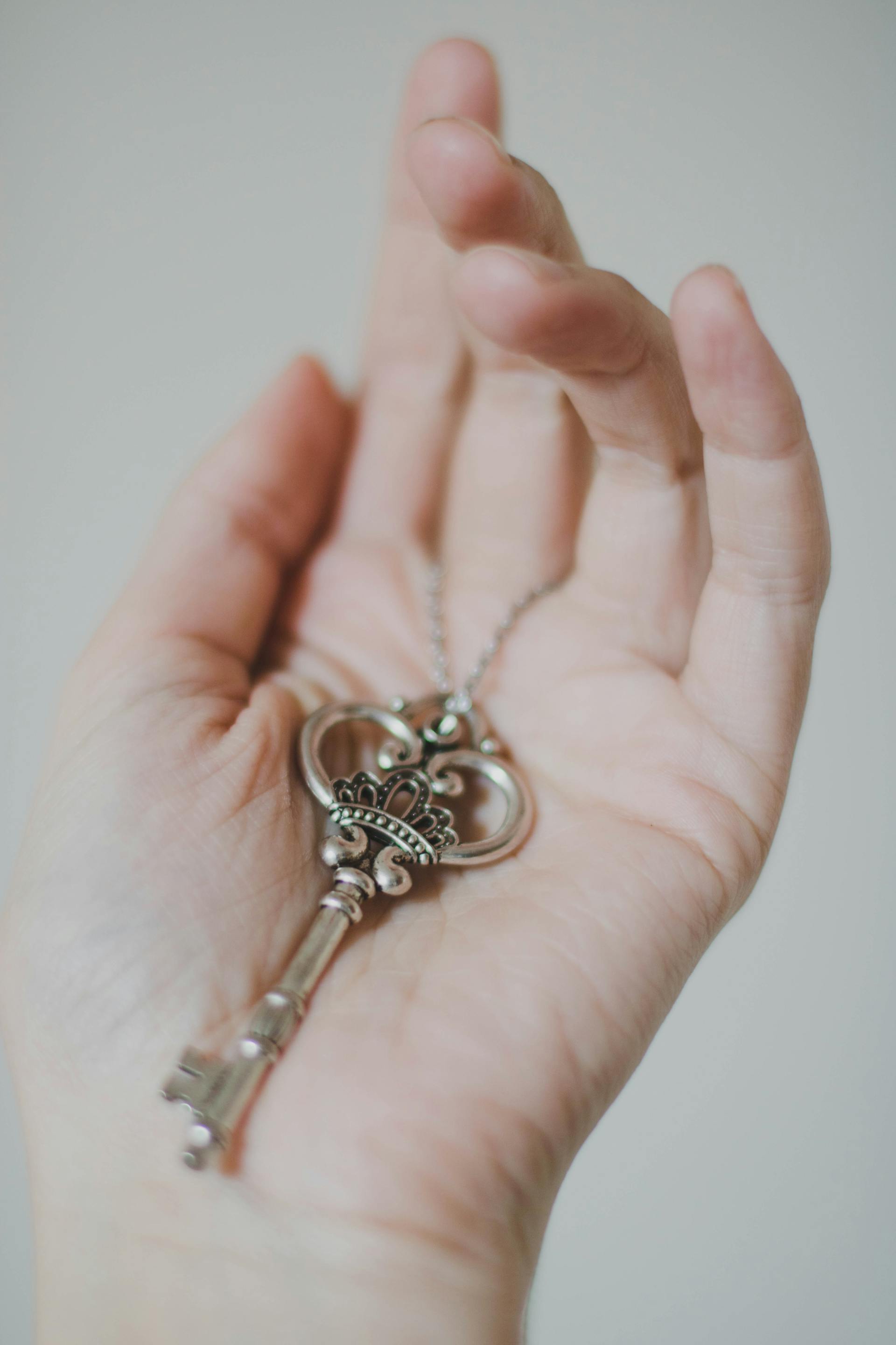 A person holding a silver-colored skeleton key | Source: Pexels