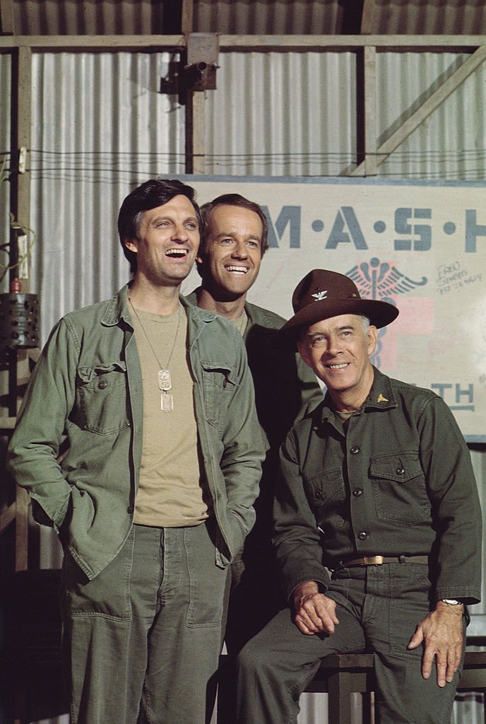 Portrait of American actors, Alan Alda, as Captain Benjamin Hawkeye Pierce, Mike Farrell, as Captain B.J. Hunnicut, and Harry Morgan, as Colonel Sherman T. Potter [Left to Right] on a scene of the  television show, "M*A*S*H" in 1981 | Source: Getty Images