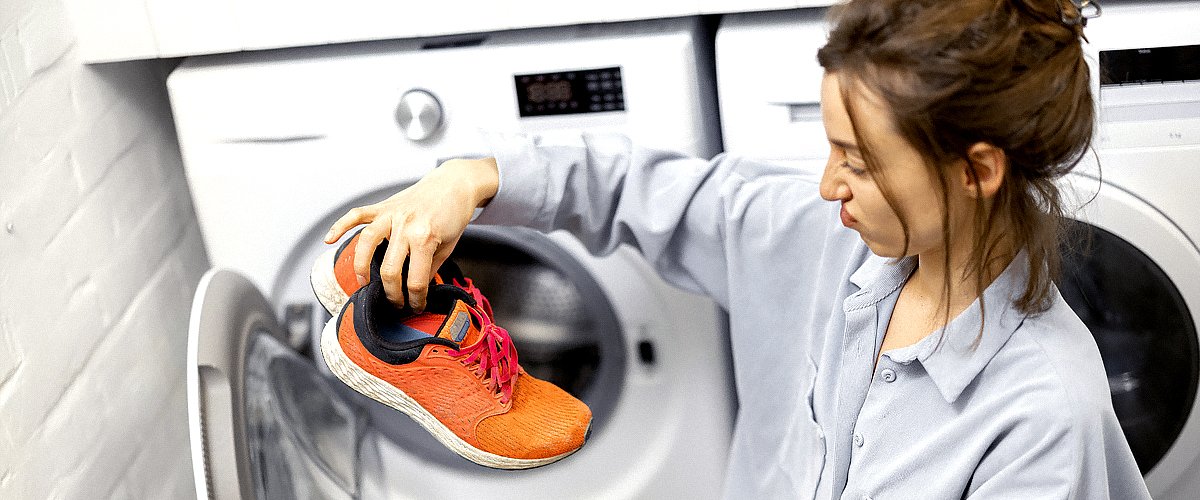 Mujer metiendo sus zapatos deportivos sucios en la lavadora. | Foto: iStockPhoto
