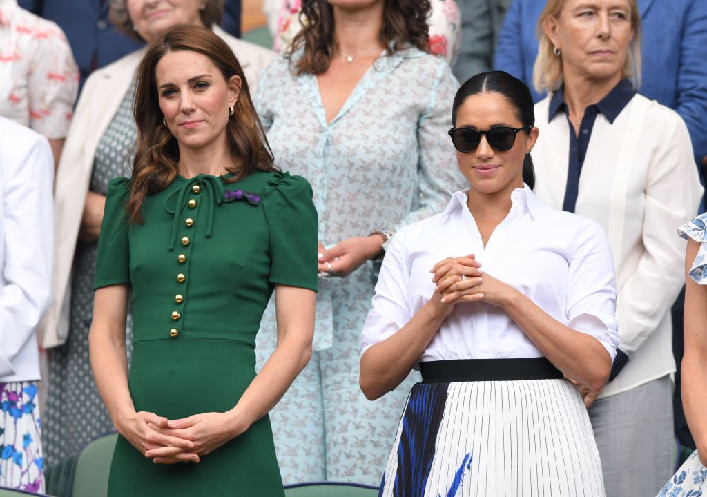Catherine, duchesse de Cambridge s'entretient avec Meghan, duchesse de Sussex dans la loge royale avant le début de la finale du simple féminin. | Photo : Getty Images