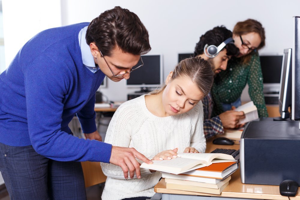 A teacher guiding his student with a reading assignment | Source: Shutterstock A teacher guiding his student with a reading assignment | Source: Shutterstock