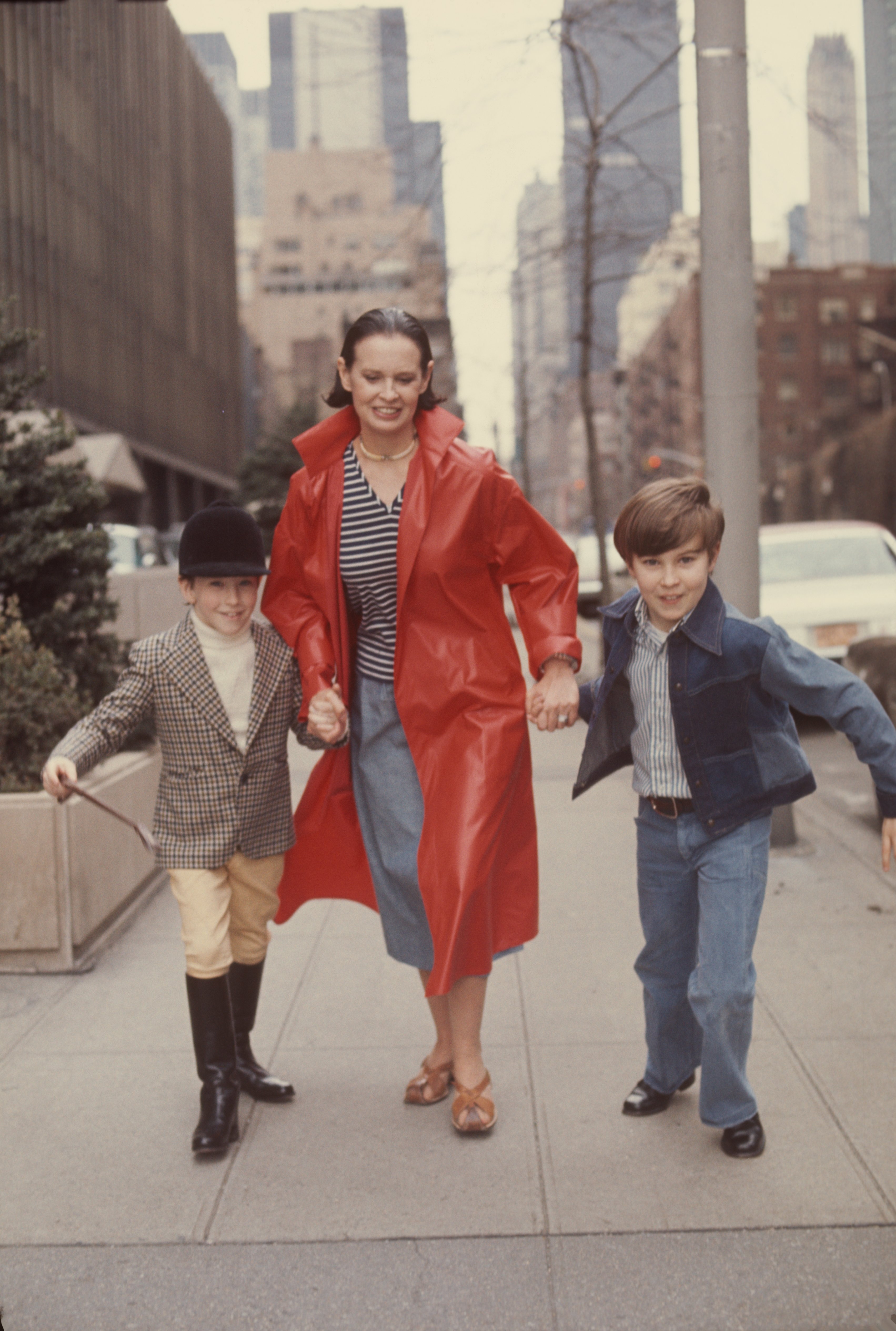 Gloria Vanderbilt runs down a street with her two sons Anderson Cooper and Carter Vanderbilt Cooper in March 1975, in New York. | Source: Getty Images