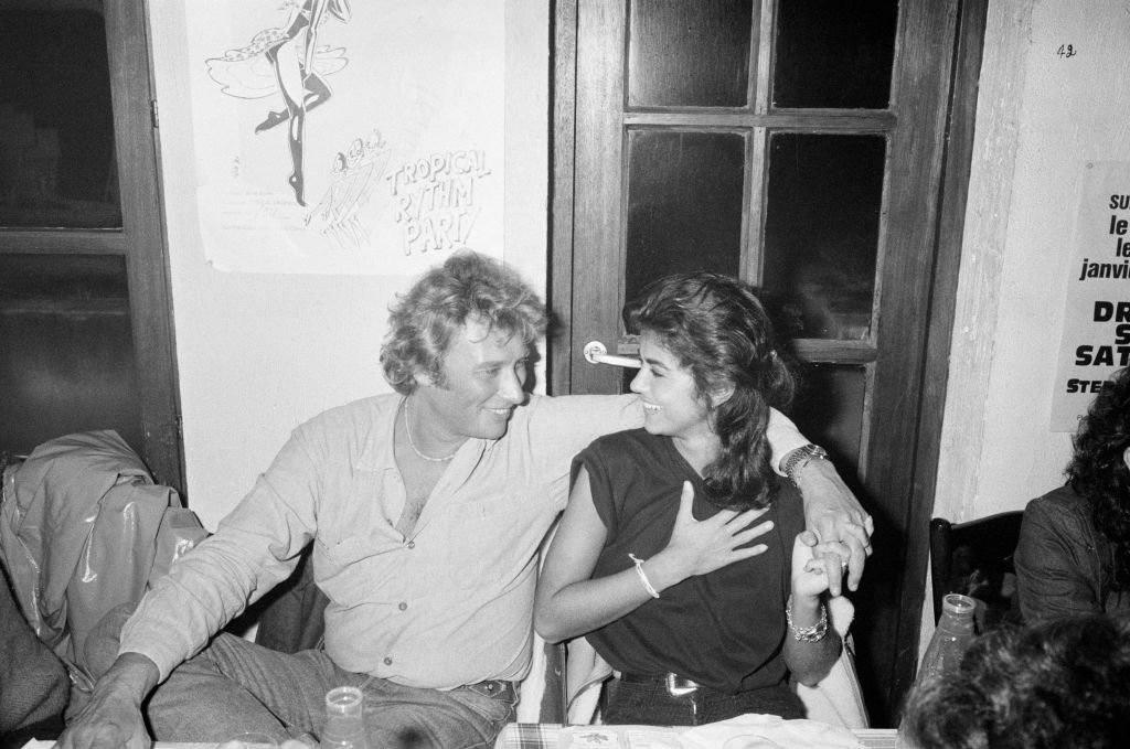 Le chanteur Johnny Hallyday se produit sur la scène du Forest National, à Forest, dans la banlieue sud de Bruxelles, dans le cadre de sa tournée Night Rider Band 1981 avec sa compagne Babeth Etienne | Photo : Getty Images