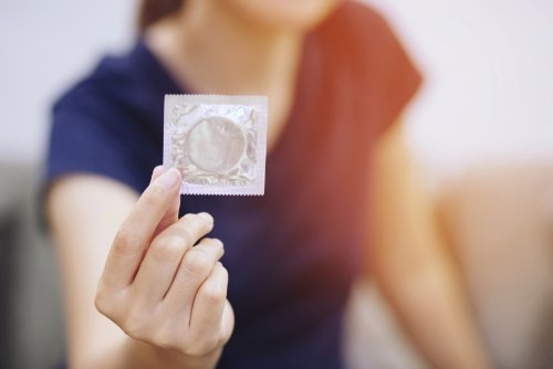 Une femme qui tient un préservatif dans la main | Photo : Shutterstock Une femme qui tient un préservatif dans la main | Photo : Shutterstock