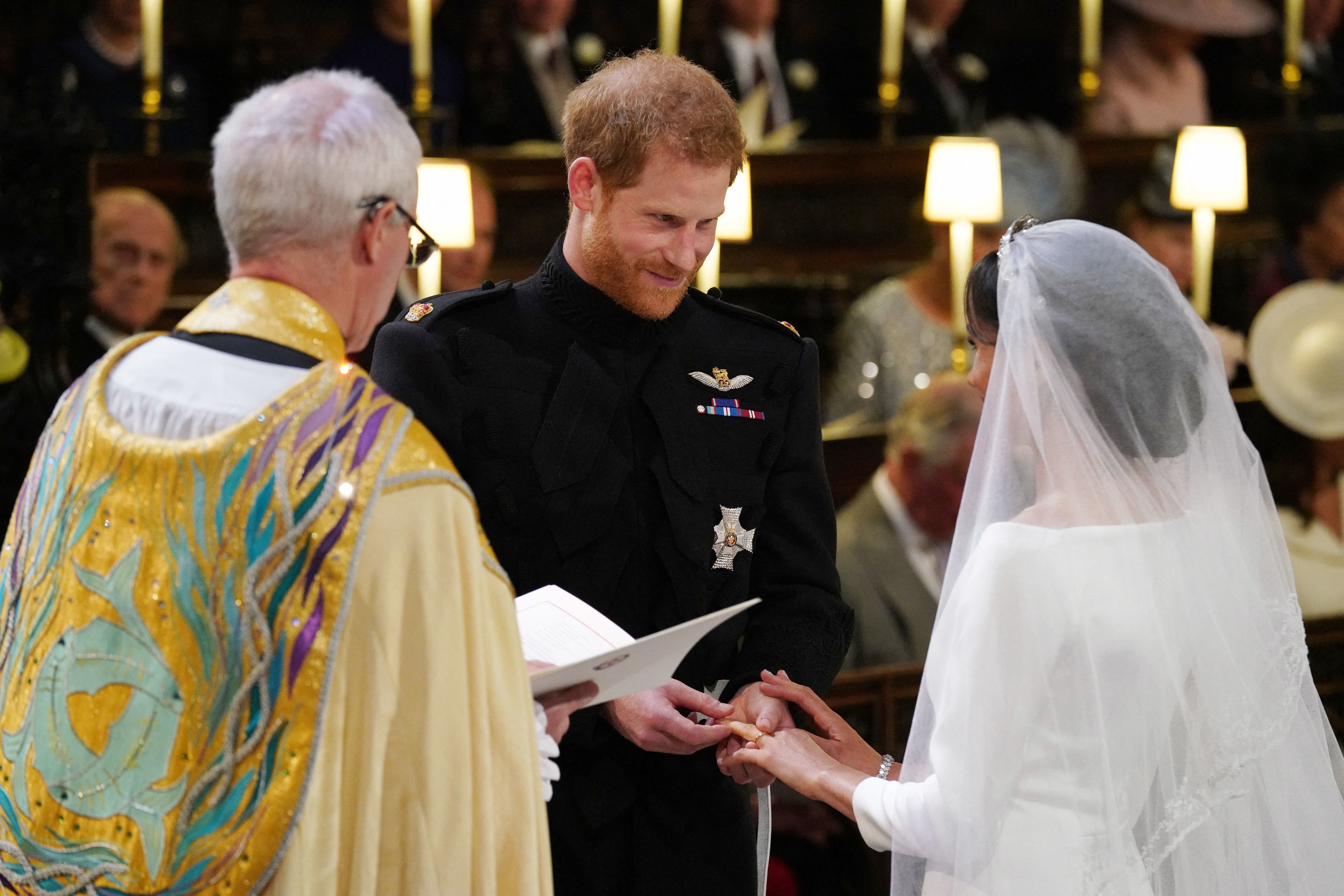 Prince Harry, Duke of Sussex, places the wedding ring on the finger of Meghan Markle during their wedding ceremony in St George's Chapel, Windsor Castle, on May 19, 2018 | Source: Getty Images