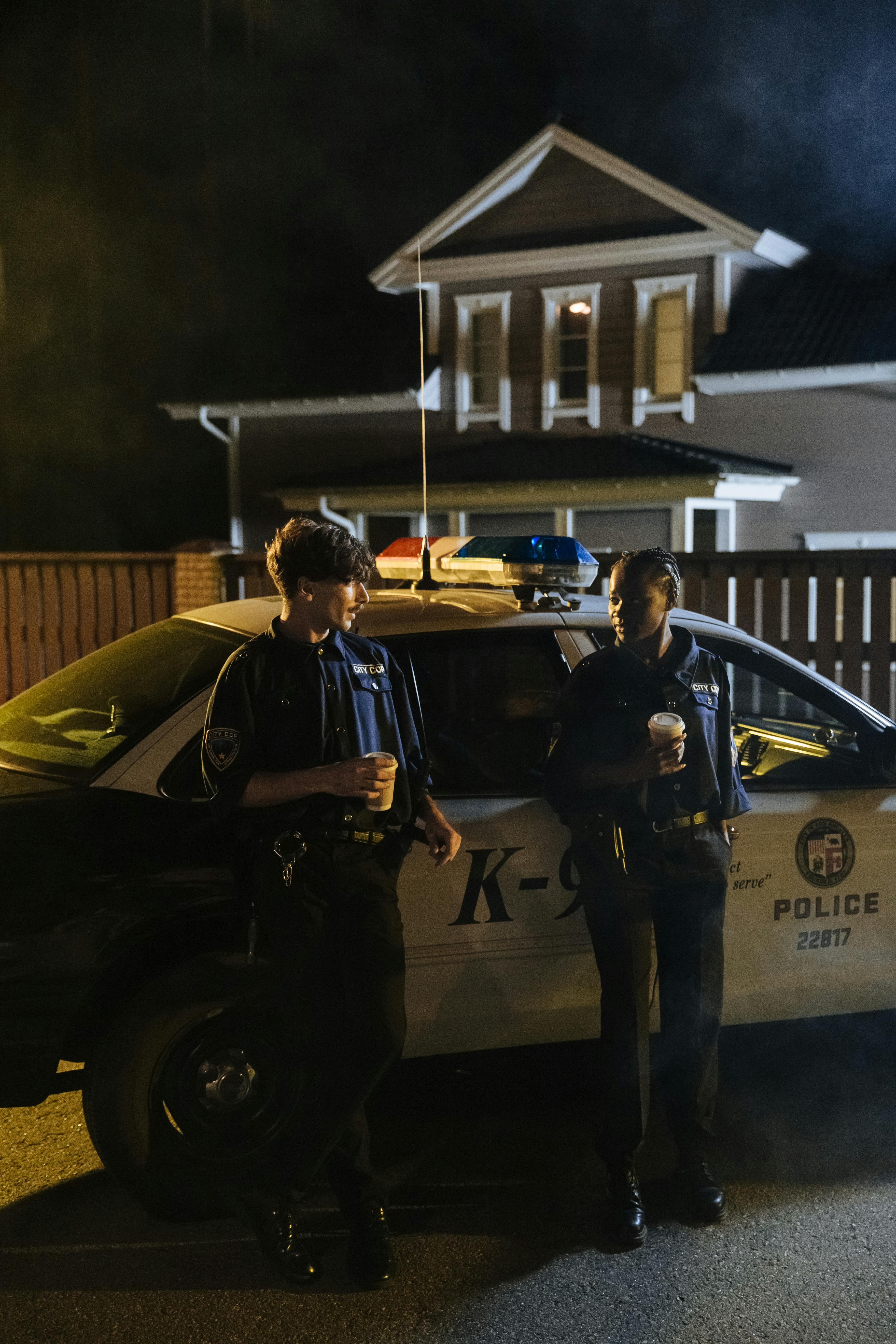 Police officers standing outside a patrol car | Source: Pexels