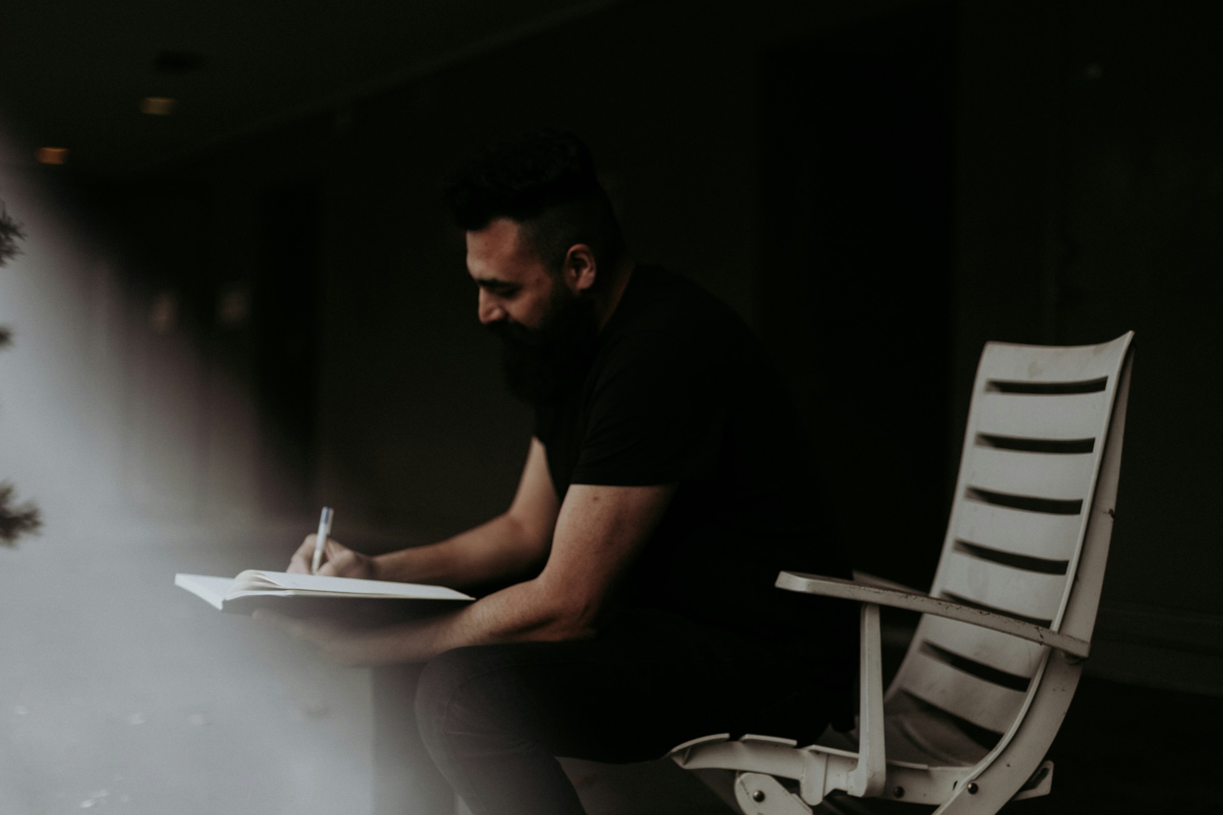 A man writing in a notebook | Source: Unsplash