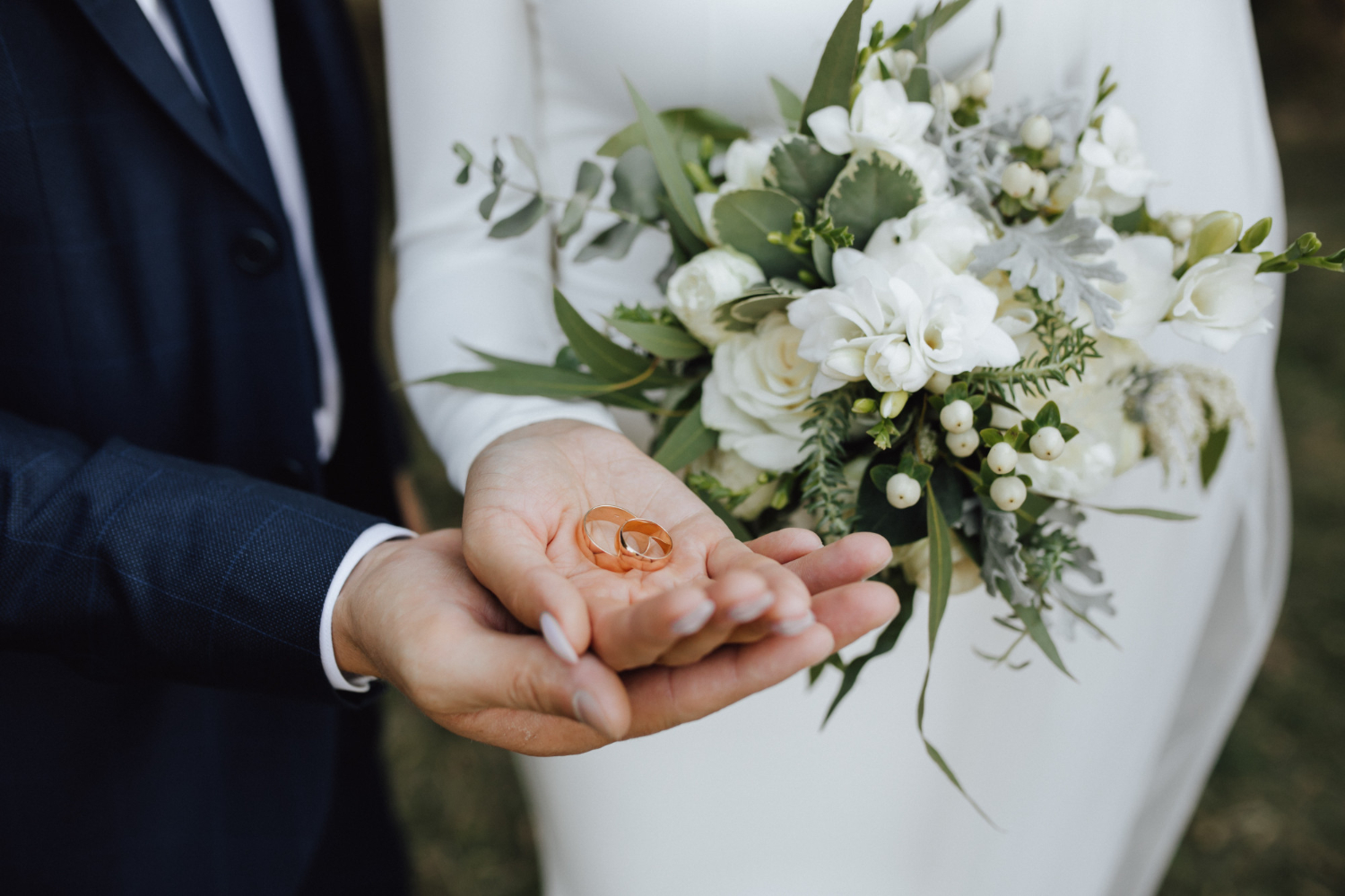 A bride and groom holding their wedding rings | Source: Freepik