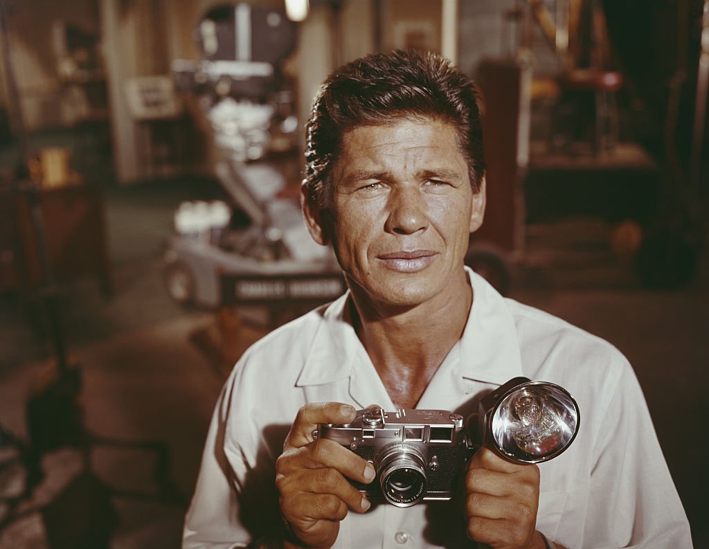 Portrait of American actor Charles Bronson (born Charles Buchinsky, 1921 - 2003) as he poses on set, with a camera in his hands, circa 1958. | Photo: Getty Images 