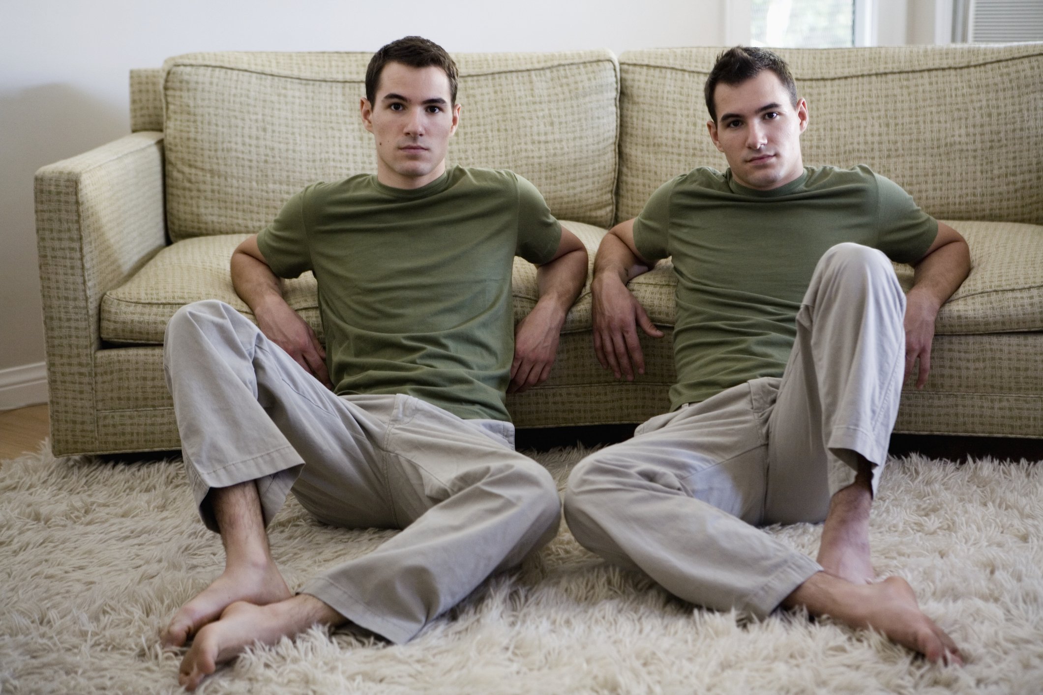 A portrait of twin brothers sitting in the living room. | Photo: Getty Images