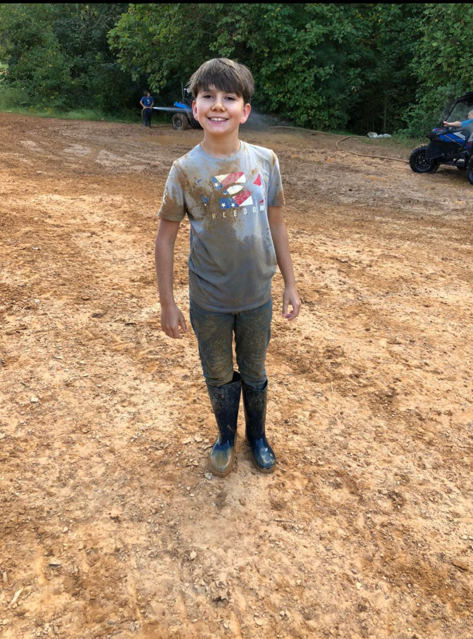 Camden Trail standing on a field in a shirt, trousers, and knee-length boots dated April 6, 2022 | Source: Facebook/Stephanie Trail